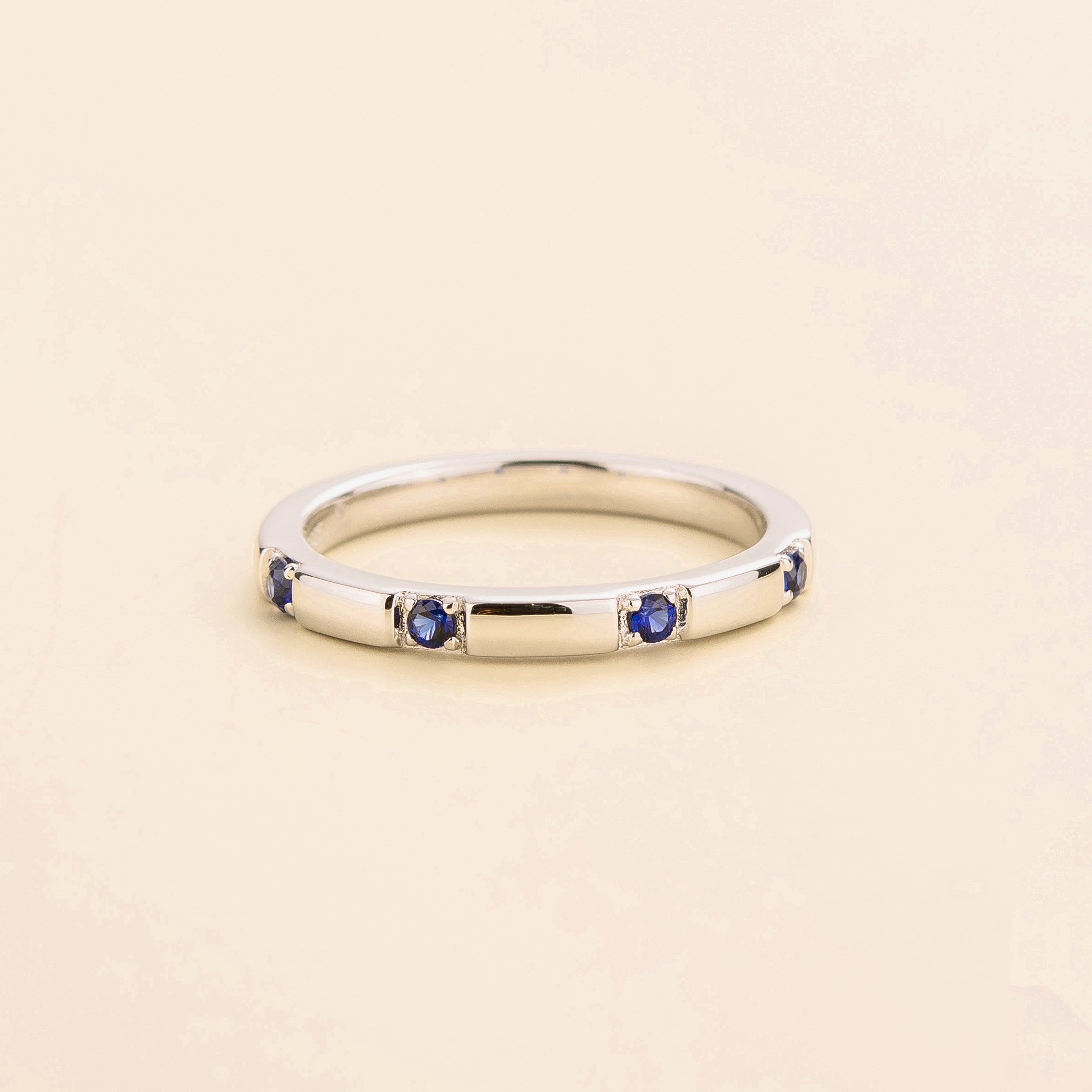 Juvetti white gold band set with round lab-grown royal blue sapphires in a sleek modern design.