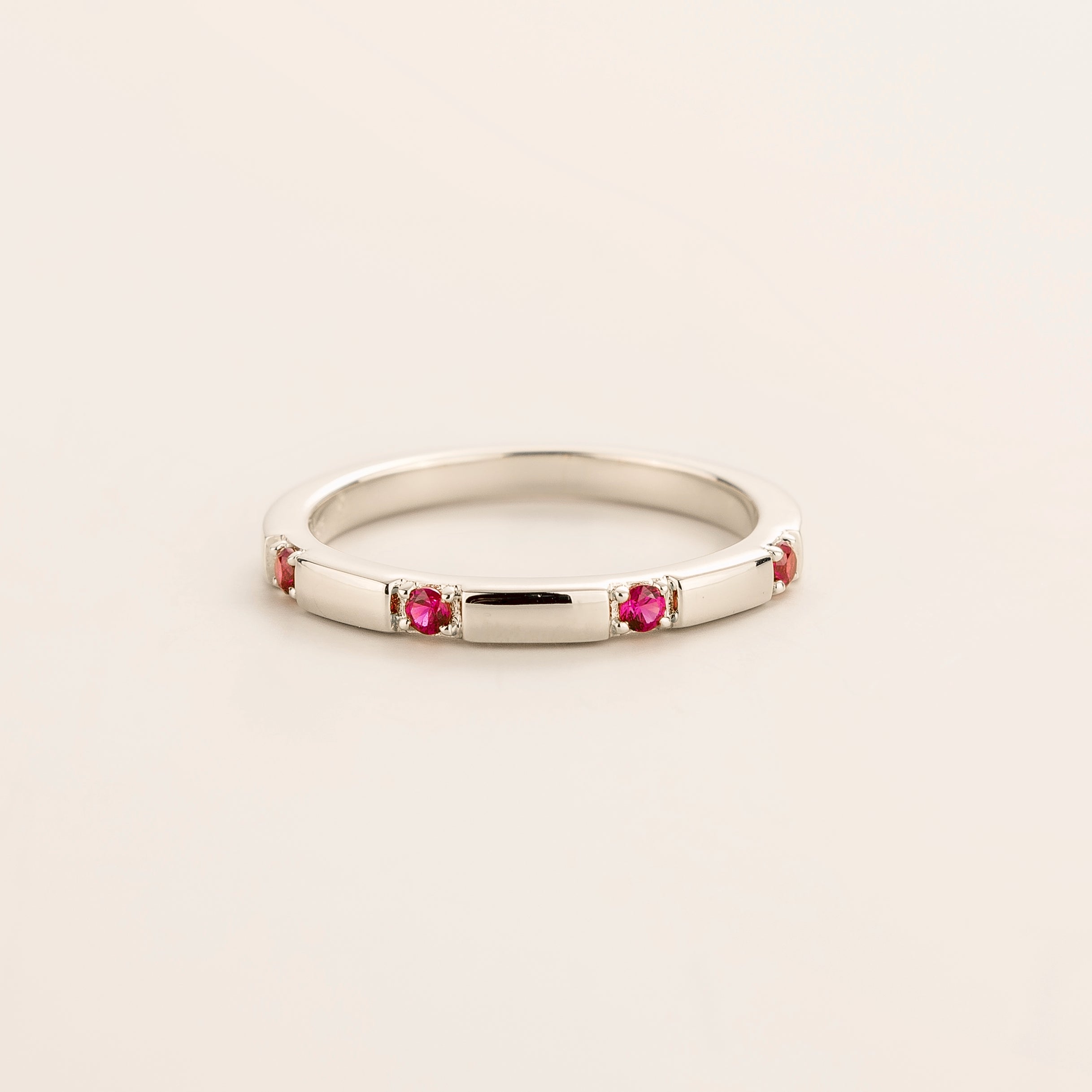 Juvetti white gold band set with round lab-grown ruby gemstones in a sleek modern design.