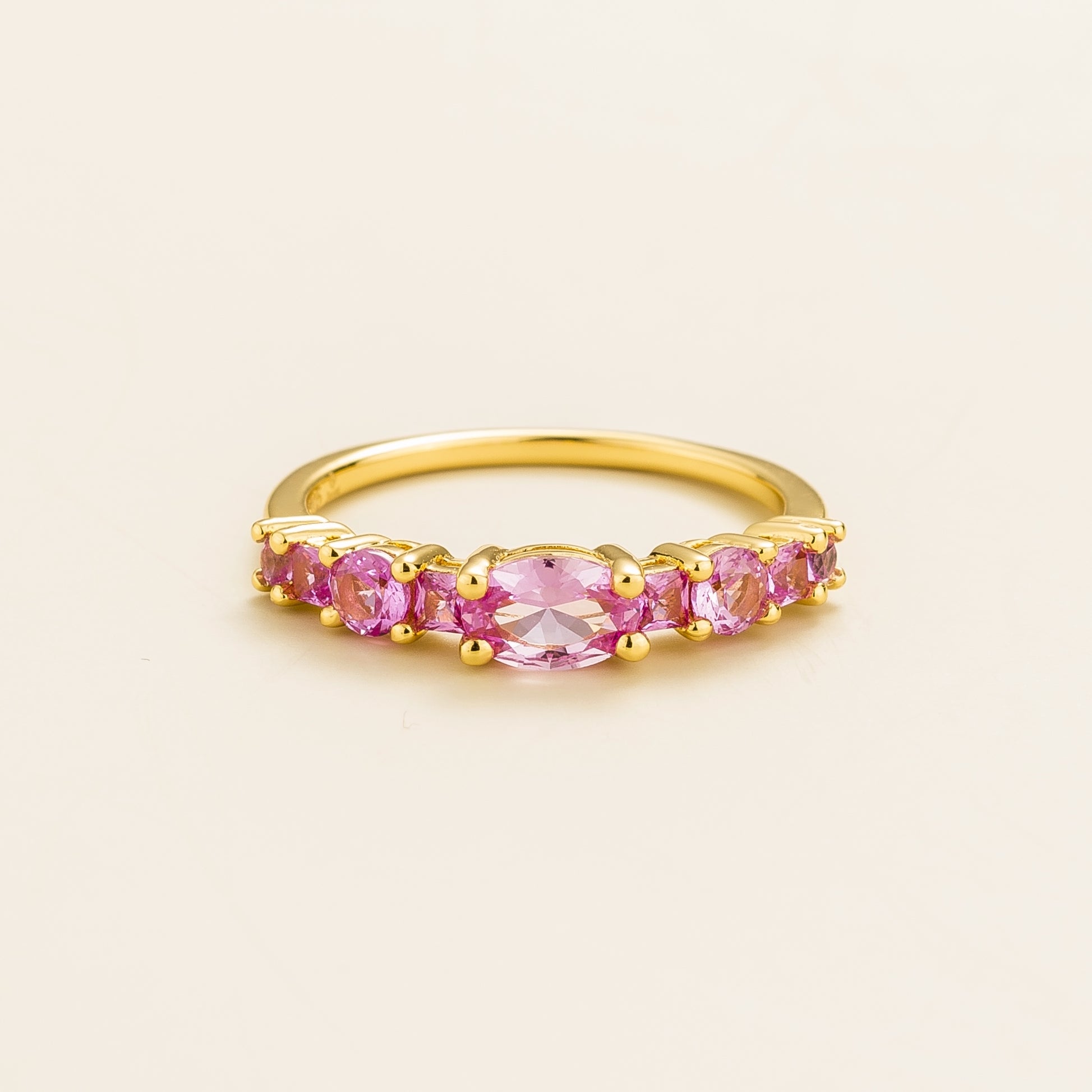 Juvetti gold ring featuring lab-grown pink sapphire in oval, princess, and round cuts for a timeless half-eternity look.