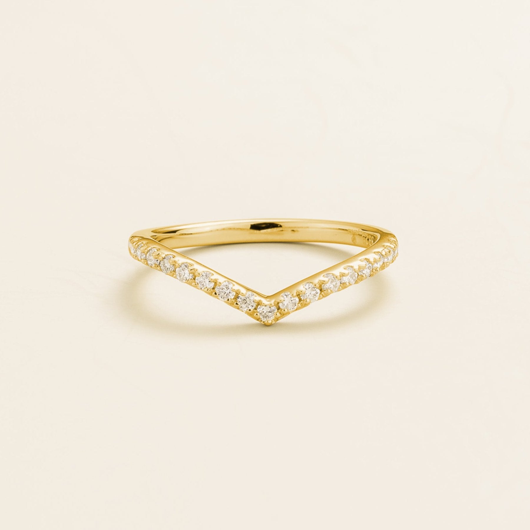 A gold ring with a chevron V-shaped design, set with diamonds.