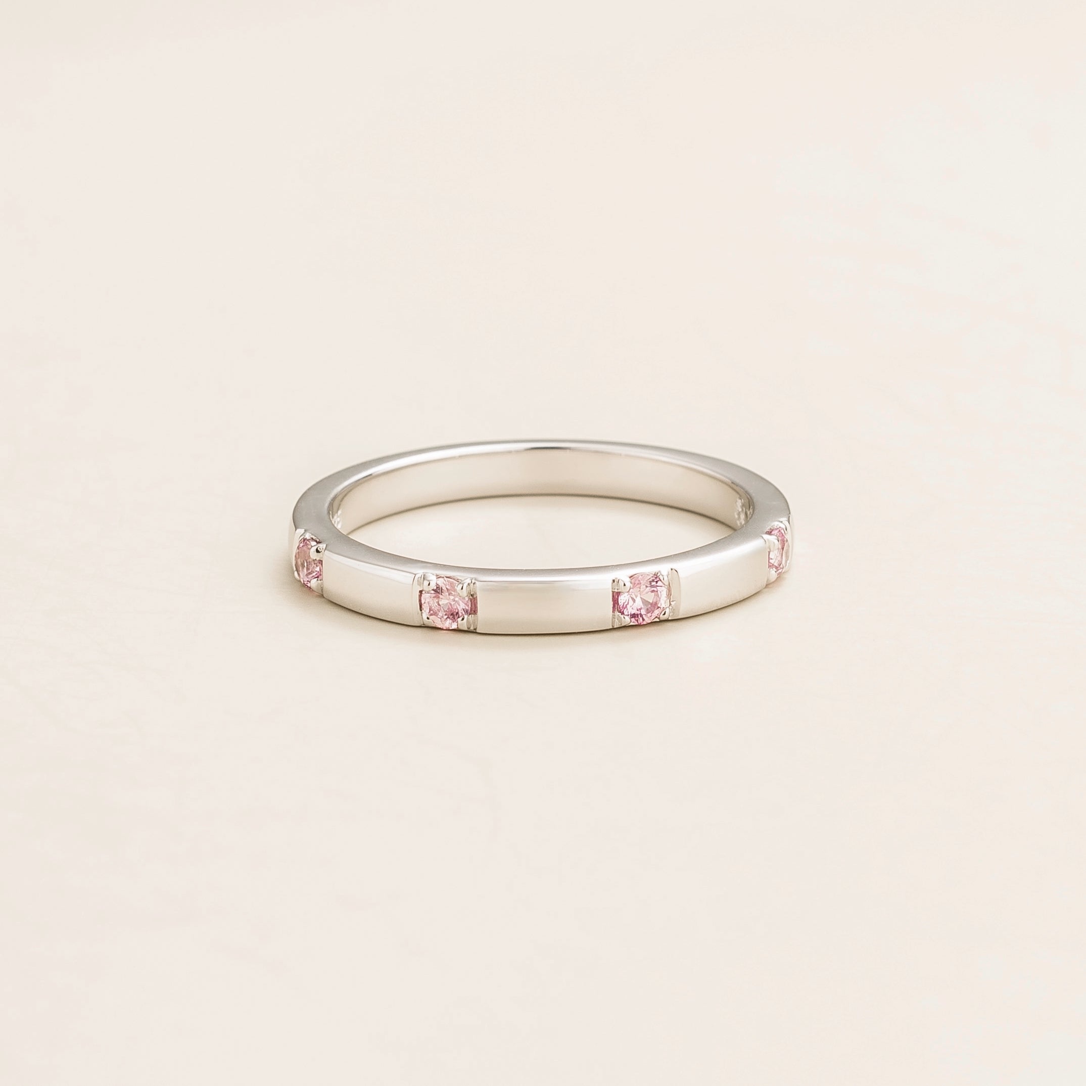 Juvetti white gold band set with round lab-grown pink sapphires in a sleek modern design.