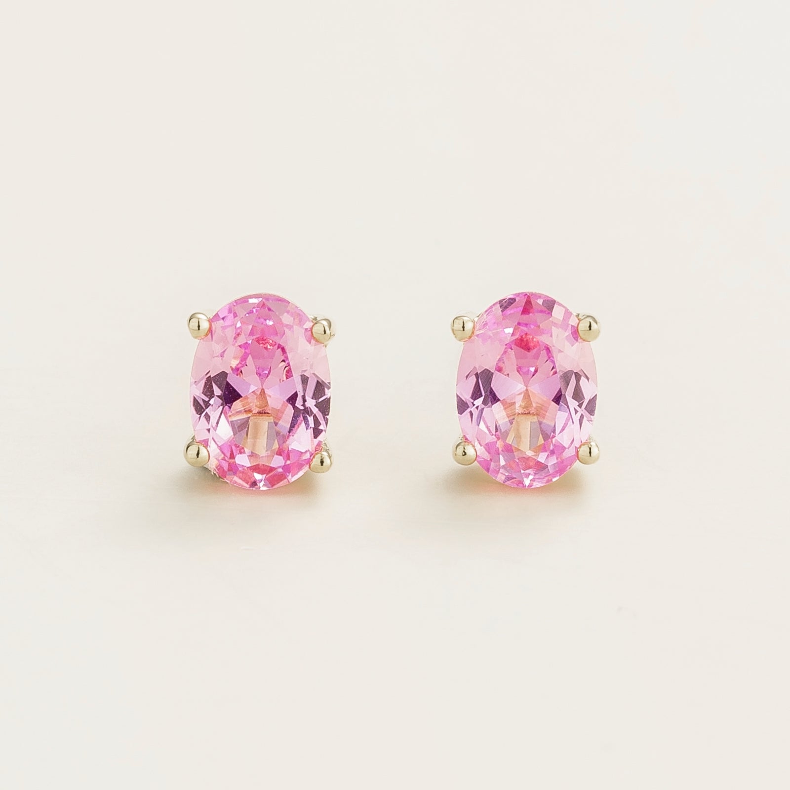 A pair of white gold stud earrings set with pink sapphires.