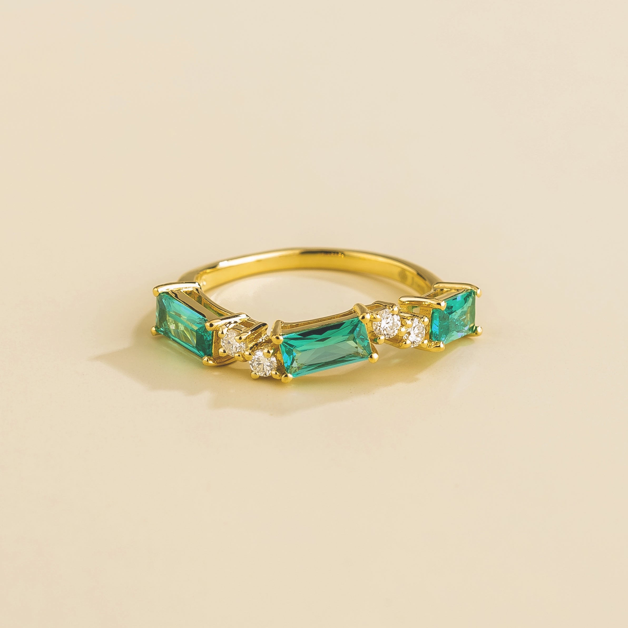 Juvetti gold ring showcasing ethical lab-grown baguette-cut paraiba sapphires and round brilliant diamonds.
