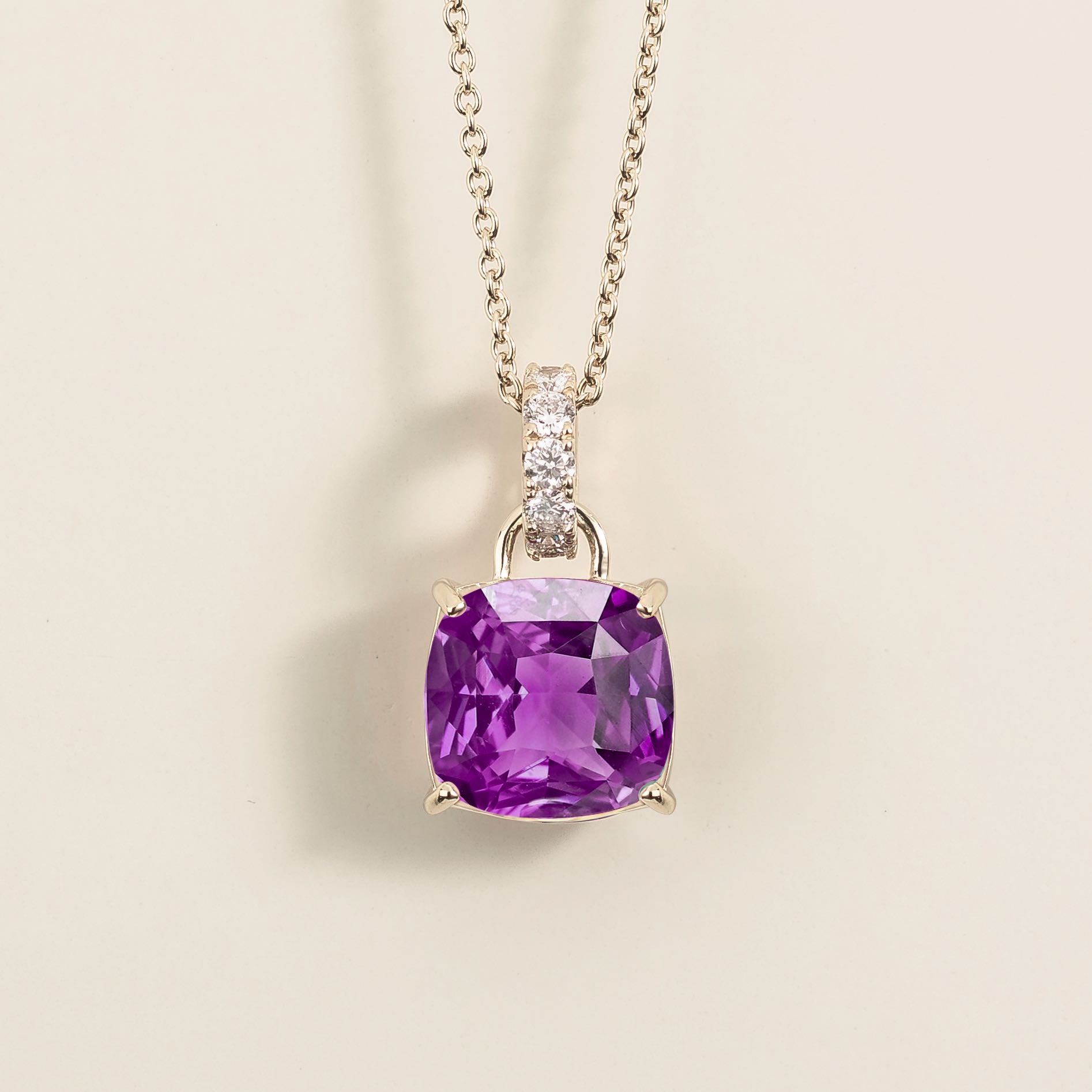 White gold pendant necklace featuring a cushion cut purple sapphire with a diamond-accented bail.