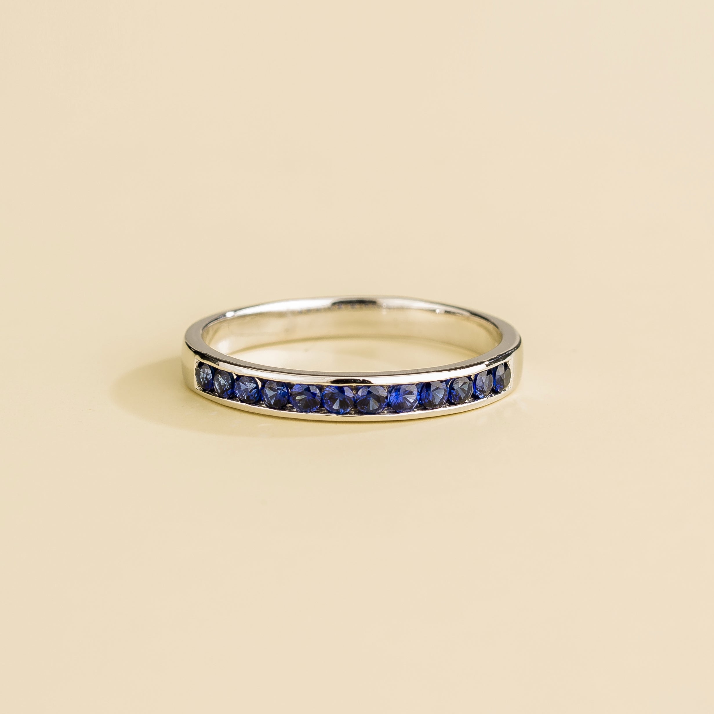 Juvetti white gold channel-set band featuring round lab-grown royal blue sapphire gemstones.