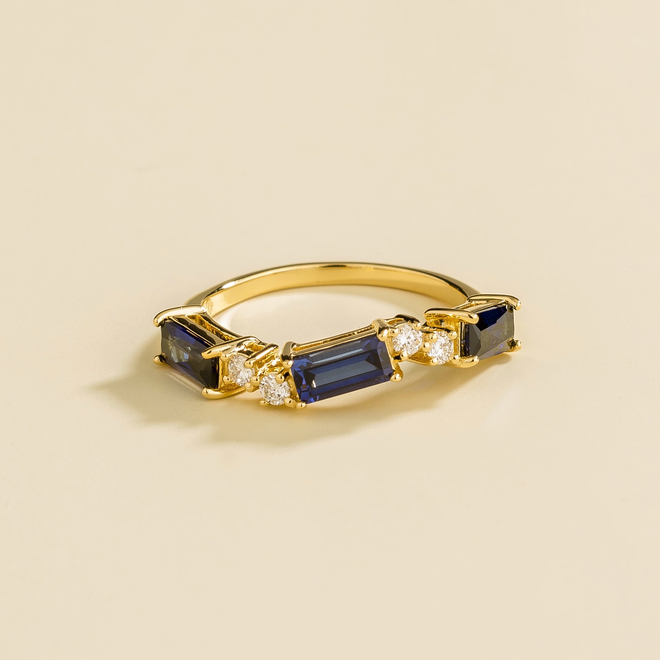Juvetti gold ring showcasing ethical lab-grown baguette-cut royal blue sapphires and round brilliant diamonds.