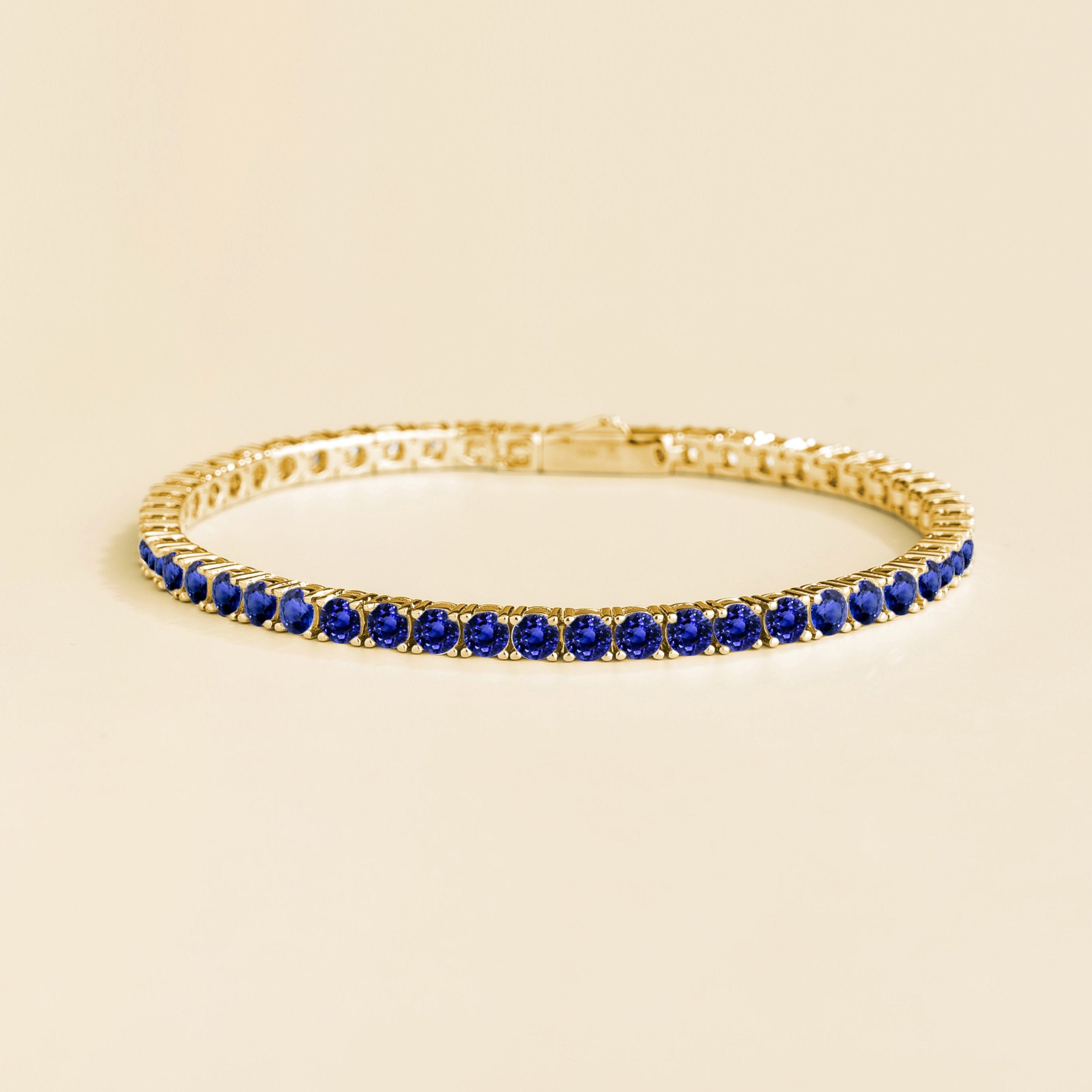 Round blue sapphire tennis bracelet set in gold