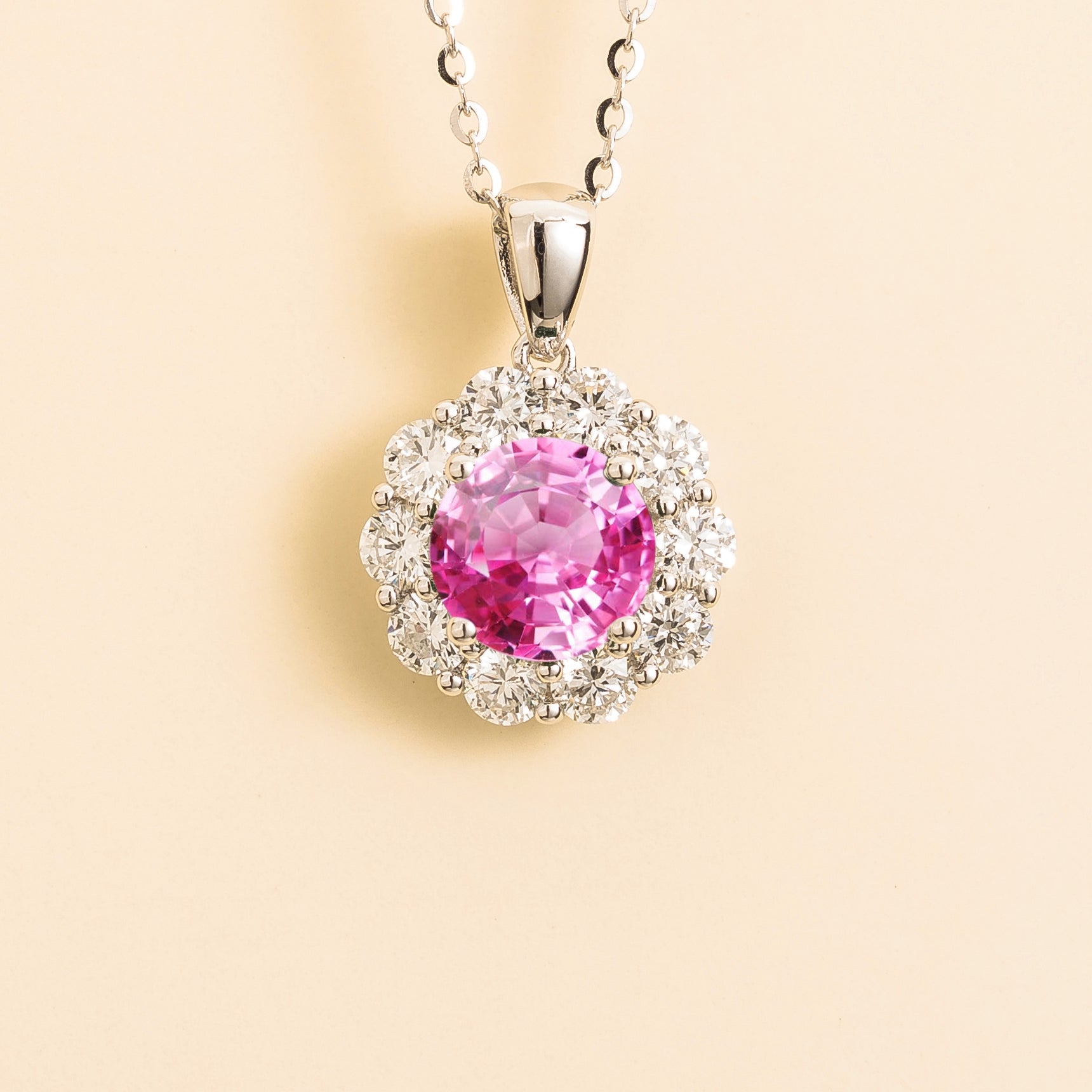 Juvetti white gold pendant necklace featuring a round lab-grown pink sapphire with a diamond halo.
