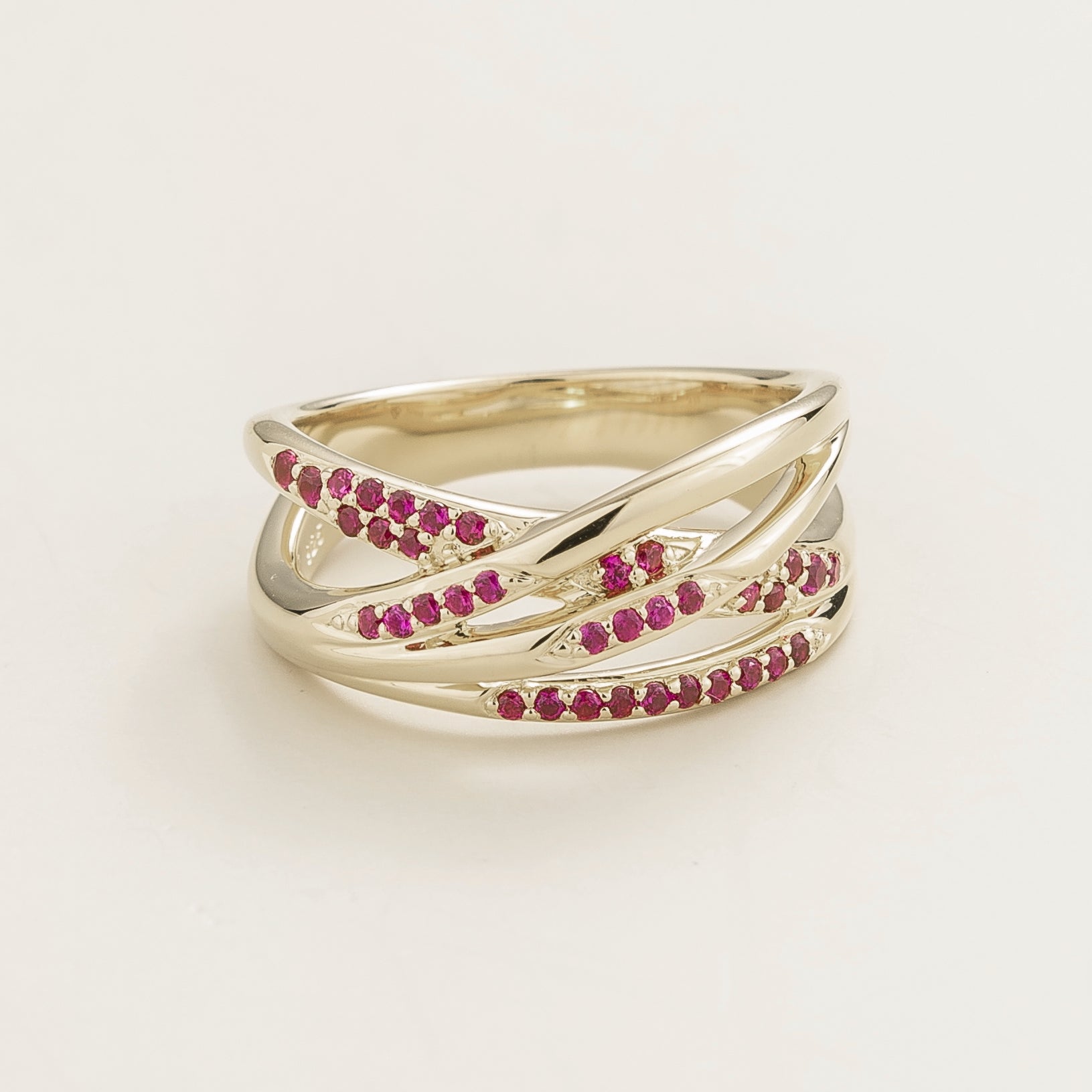 Juvetti white gold crossover ring set with round lab-grown ruby gemstones.