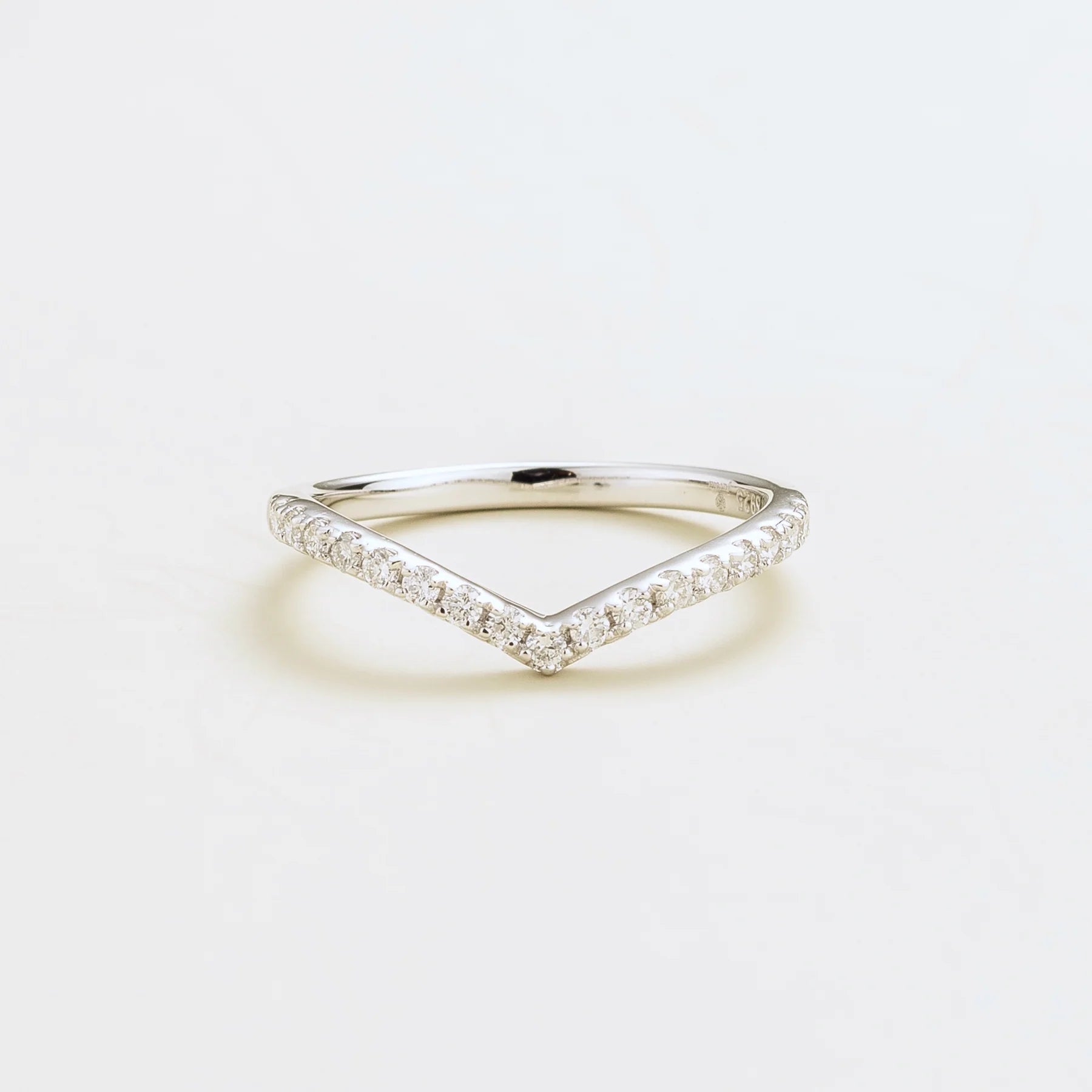 A white gold chevron ring with diamonds set in a V-shaped design.