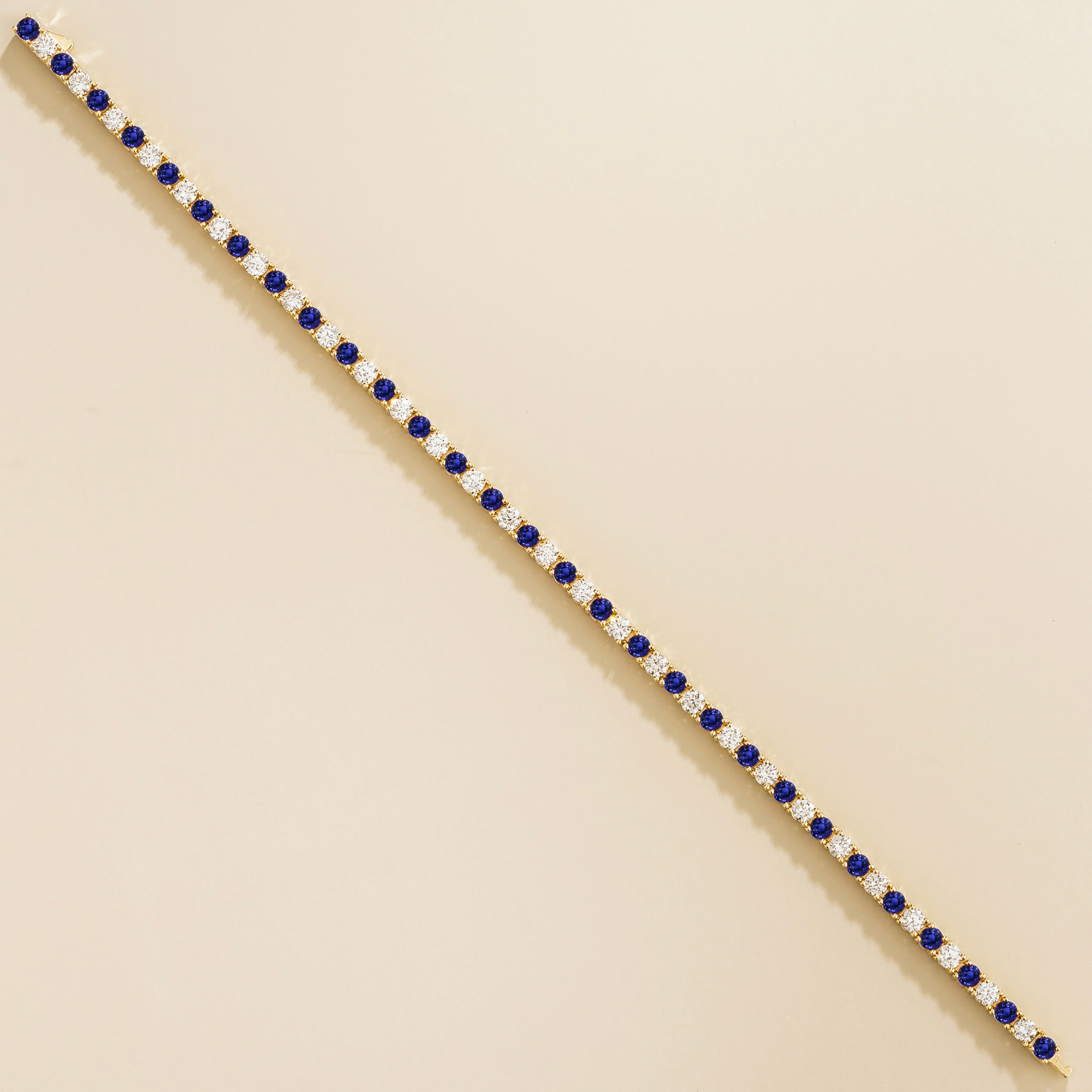 luxury tennis bracelet in gold set with blue sapphire and lab grown diamond stones