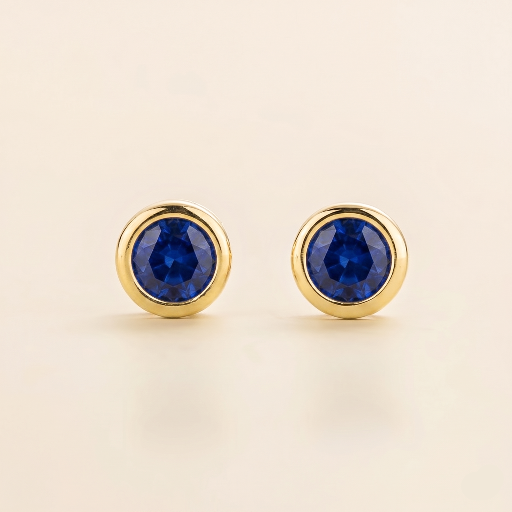Round bezel-set lab-grown blue sapphire Margo earrings in gold | Juvetti London