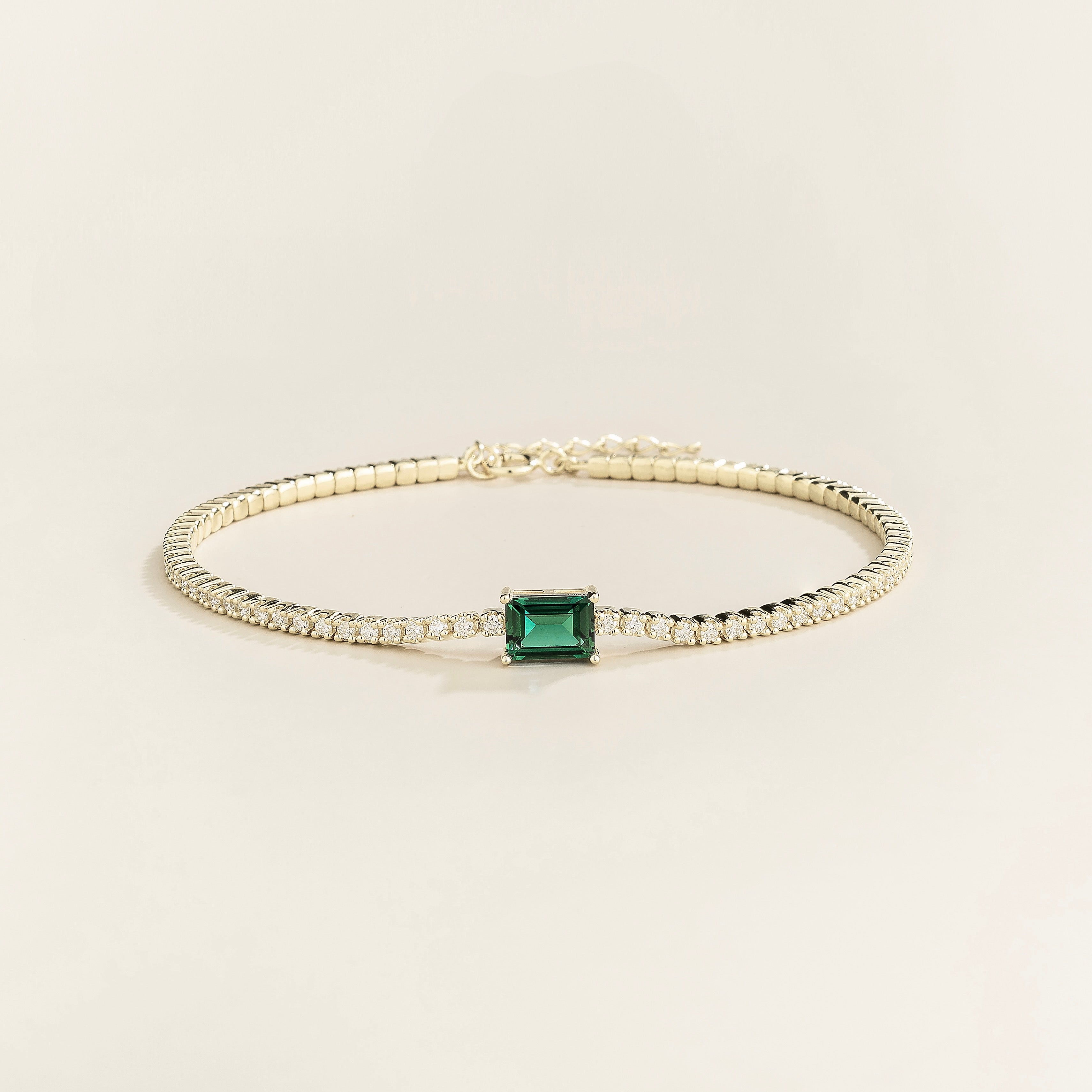 Juvetti white gold tennis bracelet featuring an emerald-cut lab-grown green sapphire with lab-grown diamond accents.