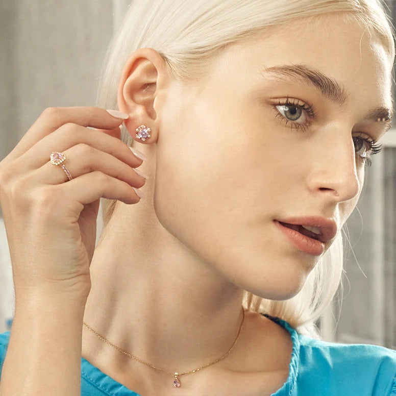 A model wearing hexagon Melba earrings, triangle Diana ring and pear drop Ori necklace set with lab grown diamond and pink sapphire gem stones.