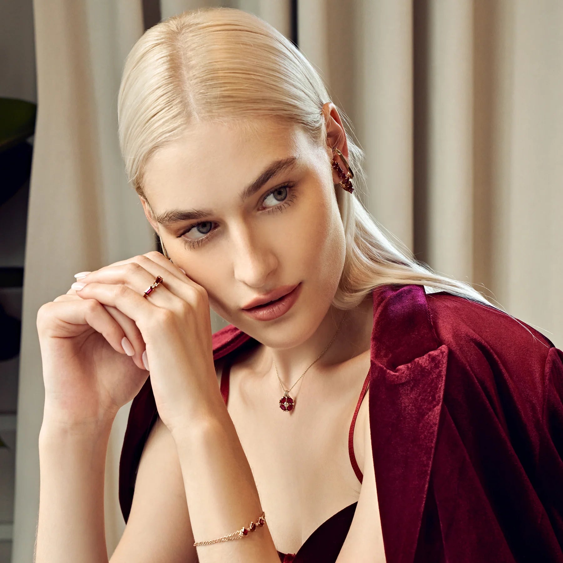 A model is wearing cuff Serene earrings, Pristi necklace and princess Forma bracelet set with lab grown ruby and diamond gem stones.