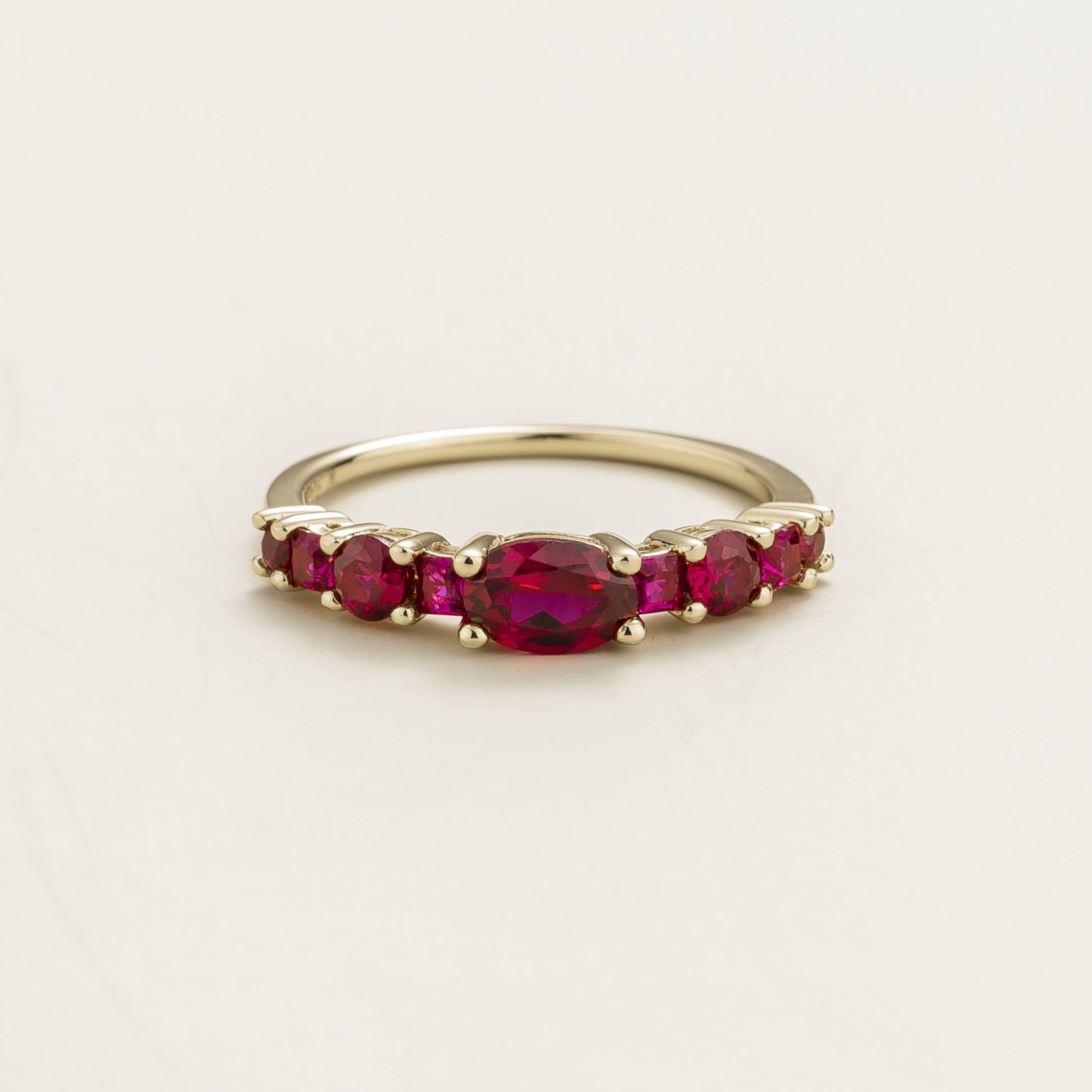 Juvetti white gold ring featuring lab-grown rubies in oval, princess, and round cuts for a timeless half-eternity look.