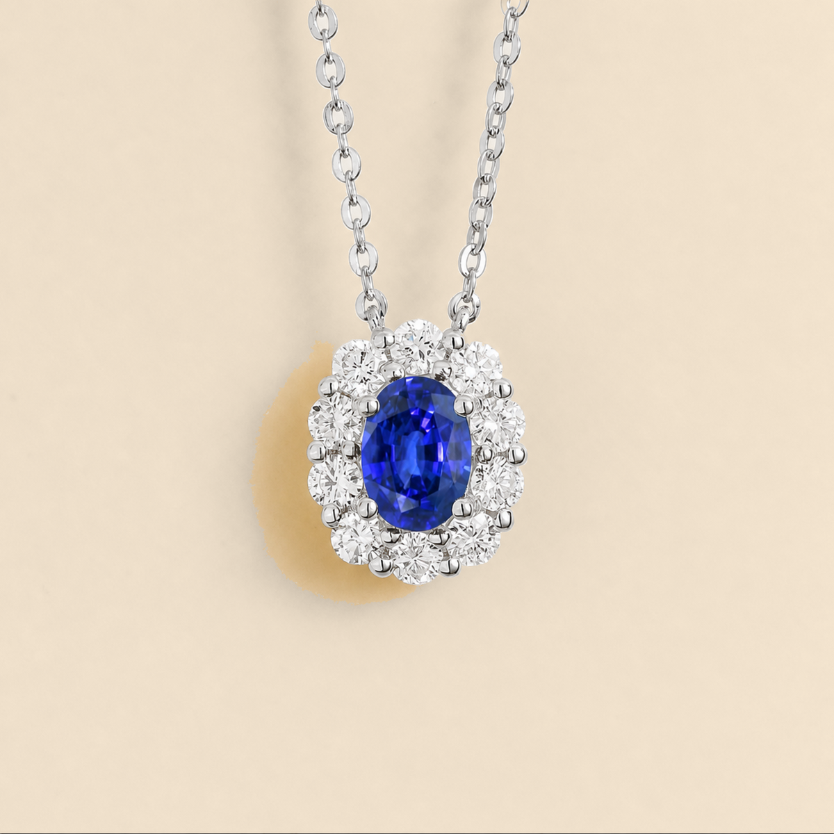 Prill Blue Sapphire Oval & Diamond Halo Pendant Necklace in White Gold | Juvetti