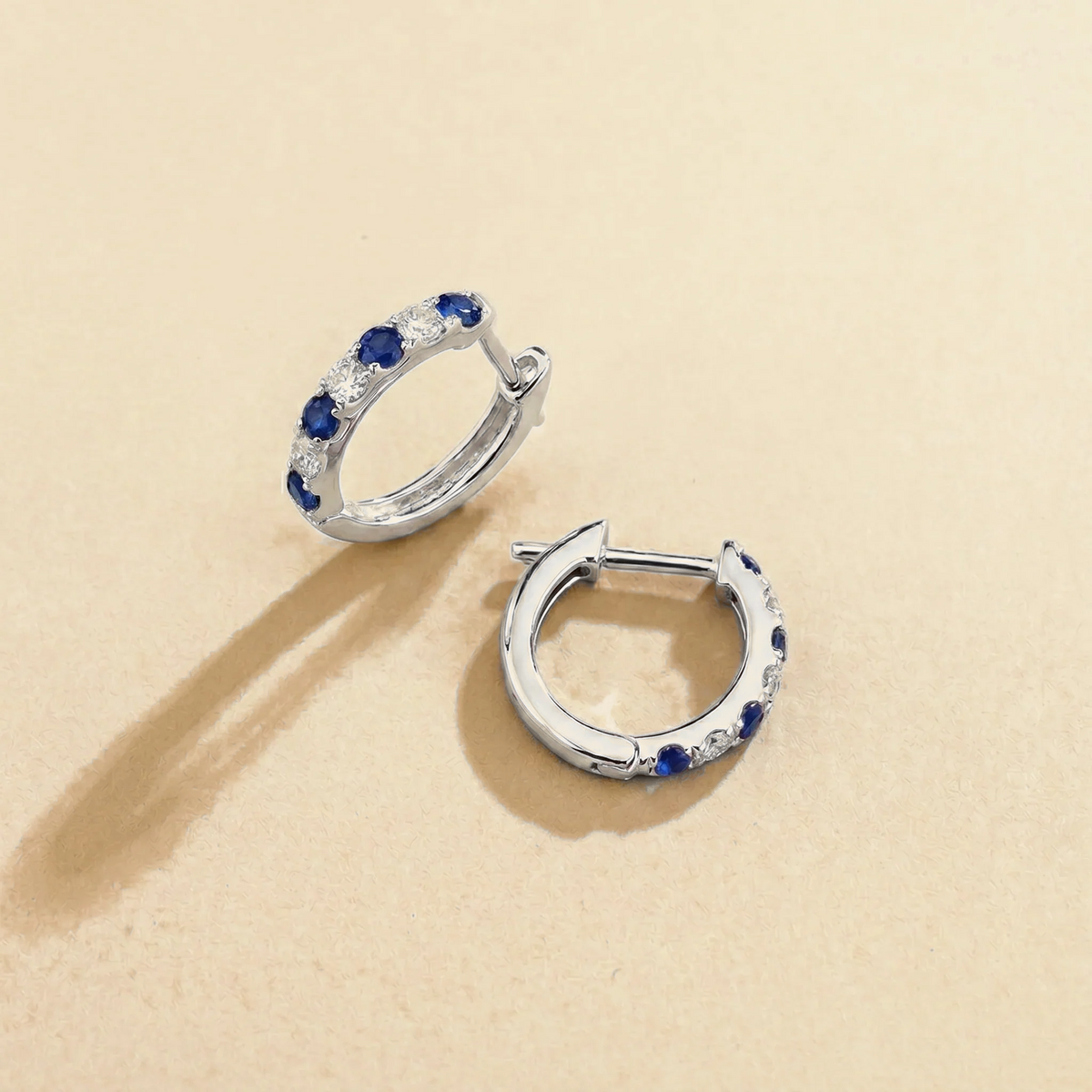 Stacy Blue Sapphire & Diamond Huggie Hoop Earrings in White Gold – angle view