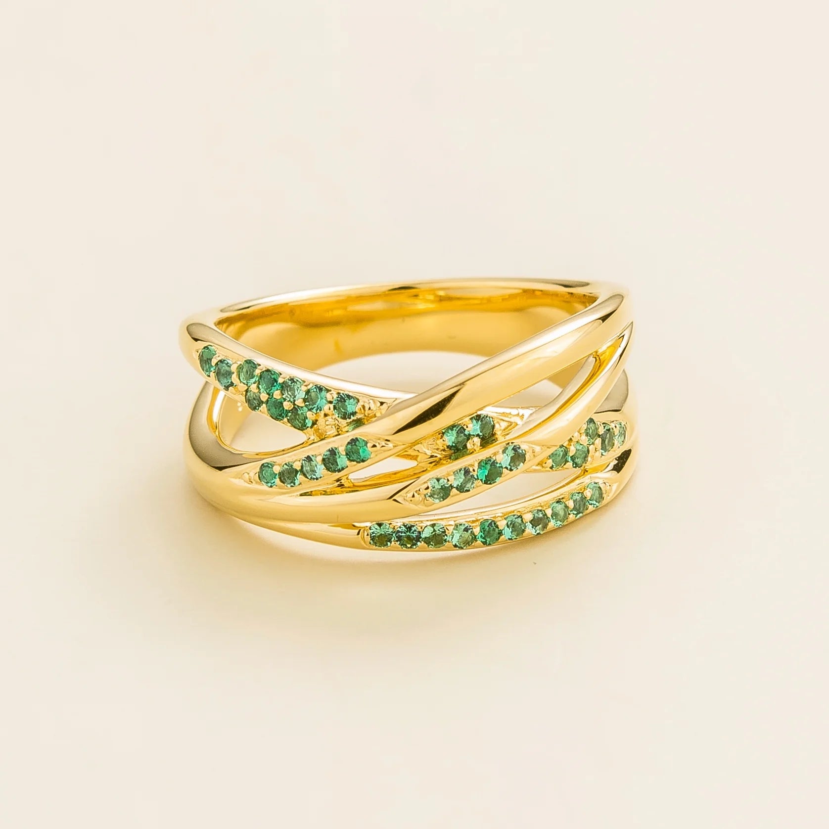 Juvetti yellow gold crossover ring set with round lab-grown emeralds.