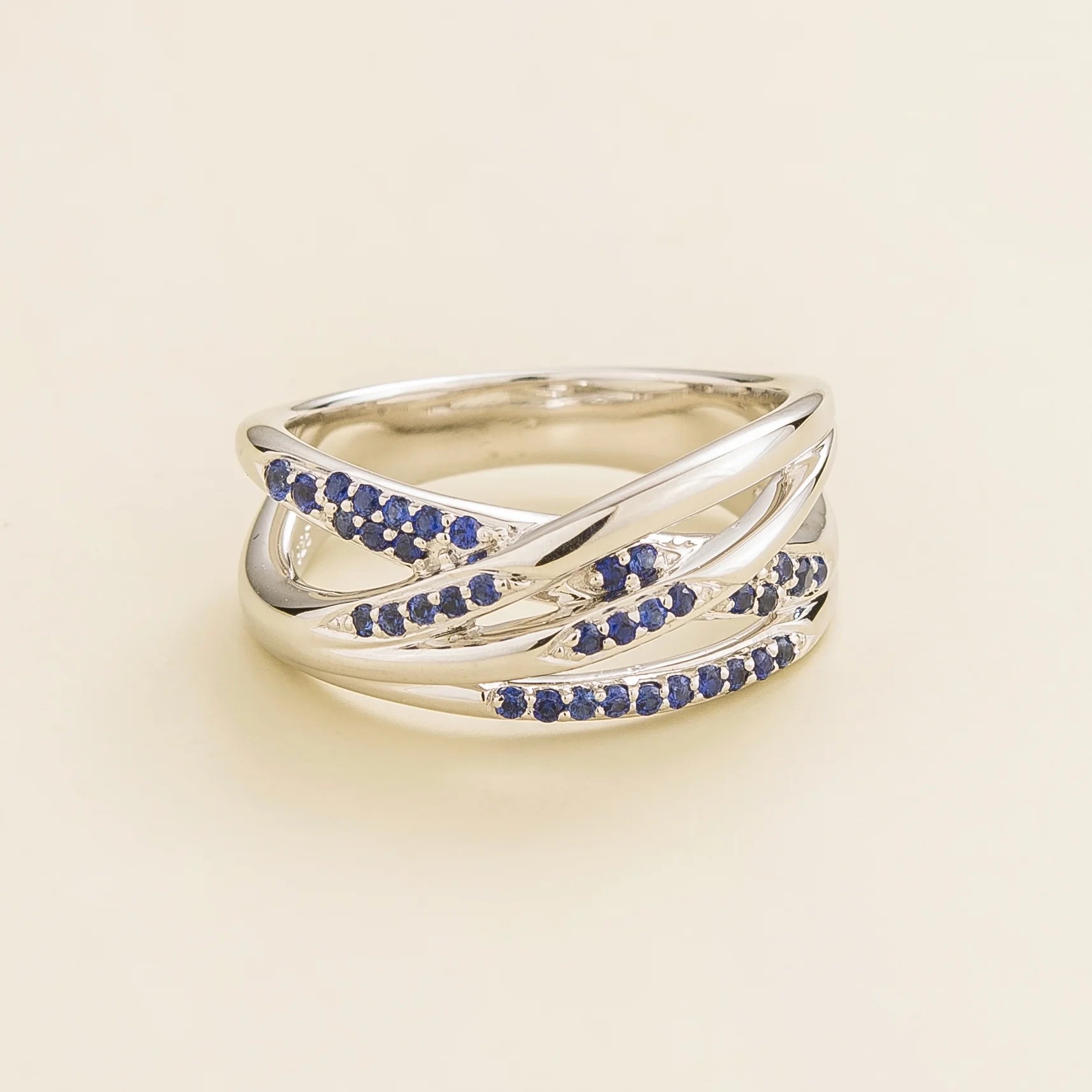 Juvetti white gold crossover ring set with round lab-grown blue sapphires.