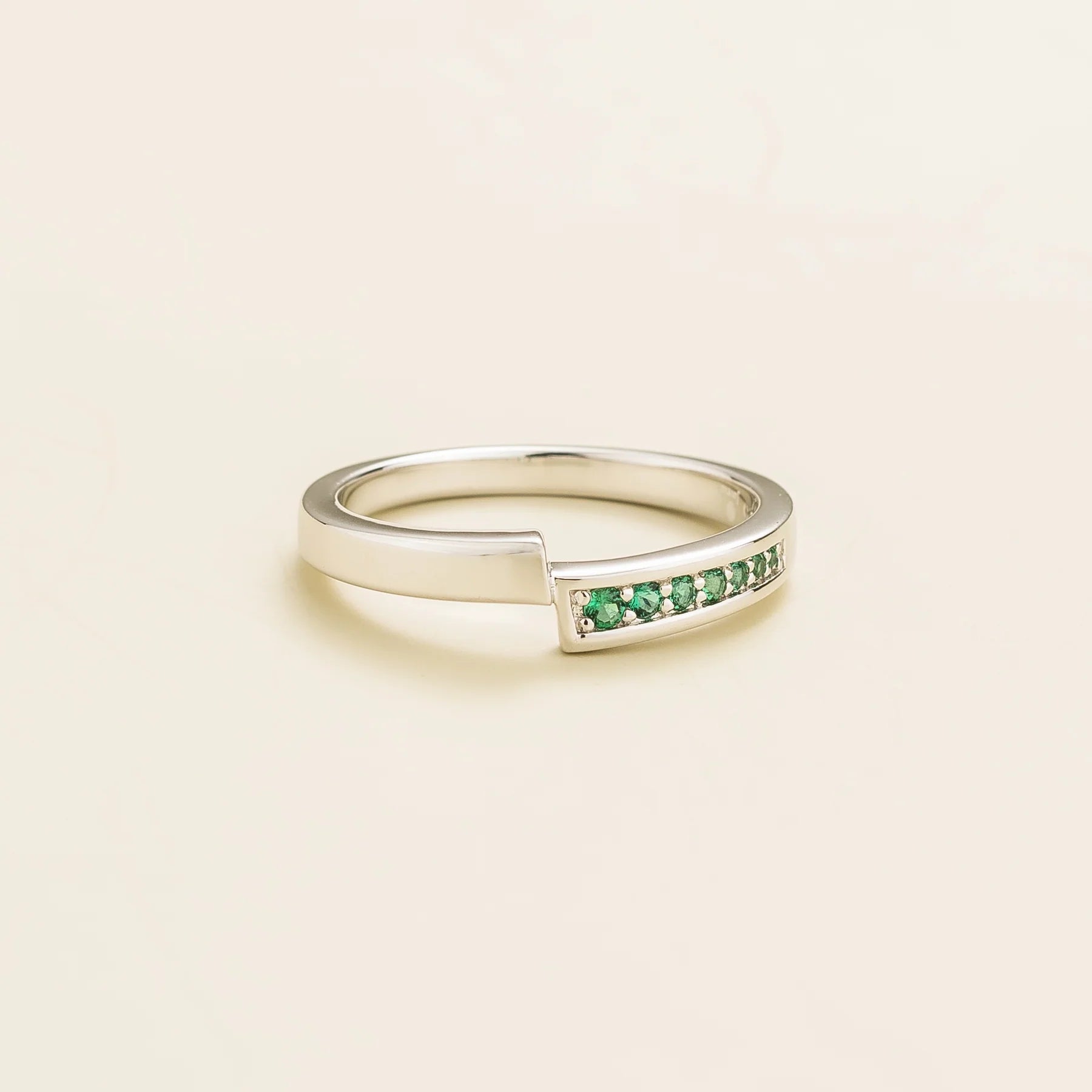 Elegant modern white gold ring featuring offset band and pavƩ-set lab-grown emerald