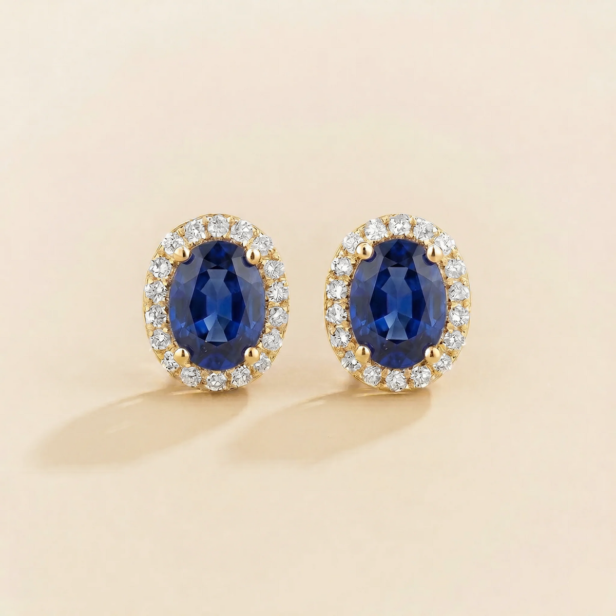 Lab-grown blue sapphire and diamond oval halo stud earrings in gold – front view | Mina by Juvetti