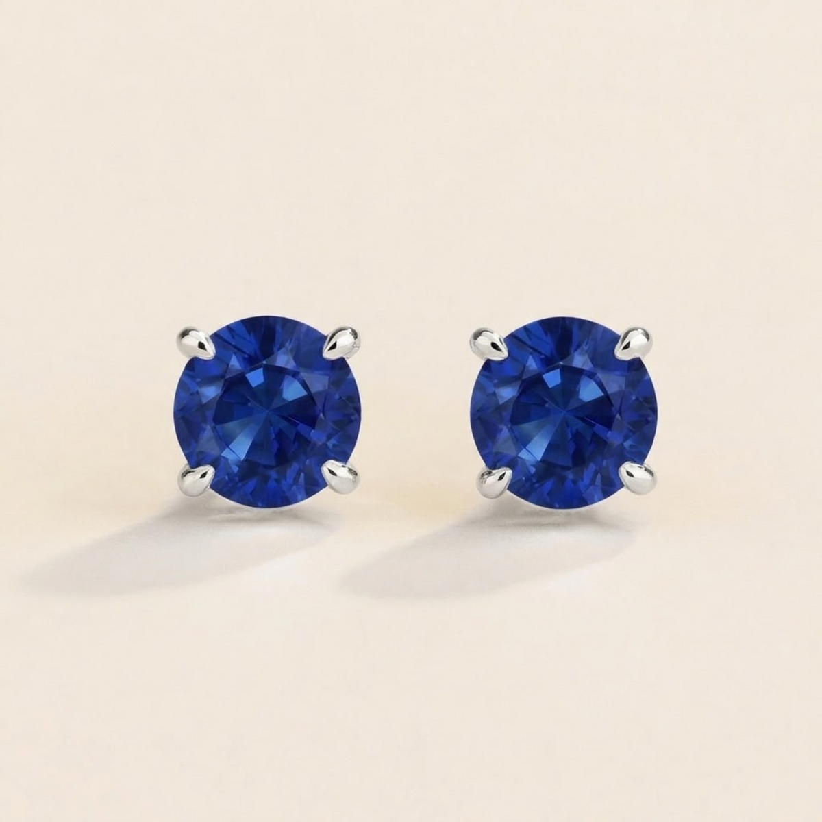 Nina round lab-grown blue sapphire solitaire stud earrings in white gold – front view | Juvetti London