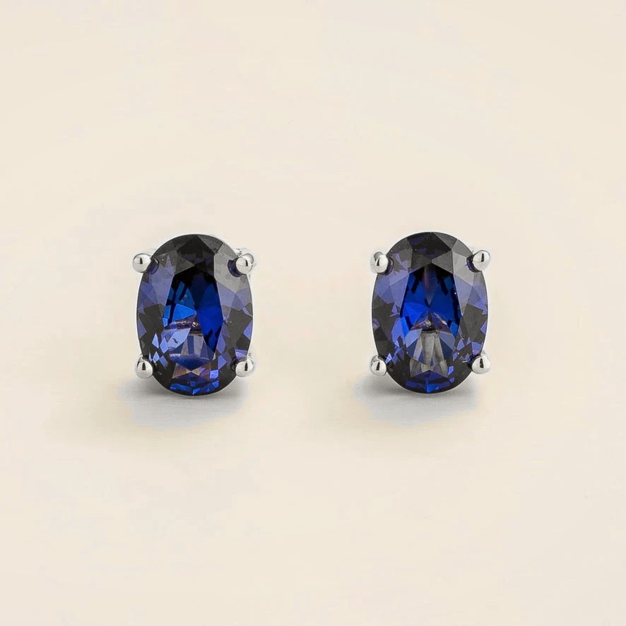 Ovo blue sapphire oval solitaire stud earrings in white gold