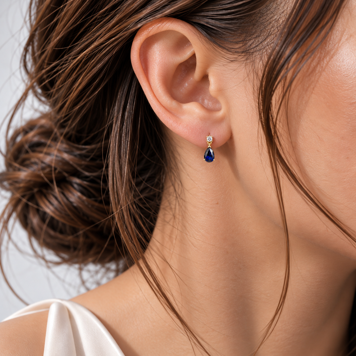 Model wearing lab-grown blue sapphire and diamond pear drop earrings in gold | Pisa by Juvetti