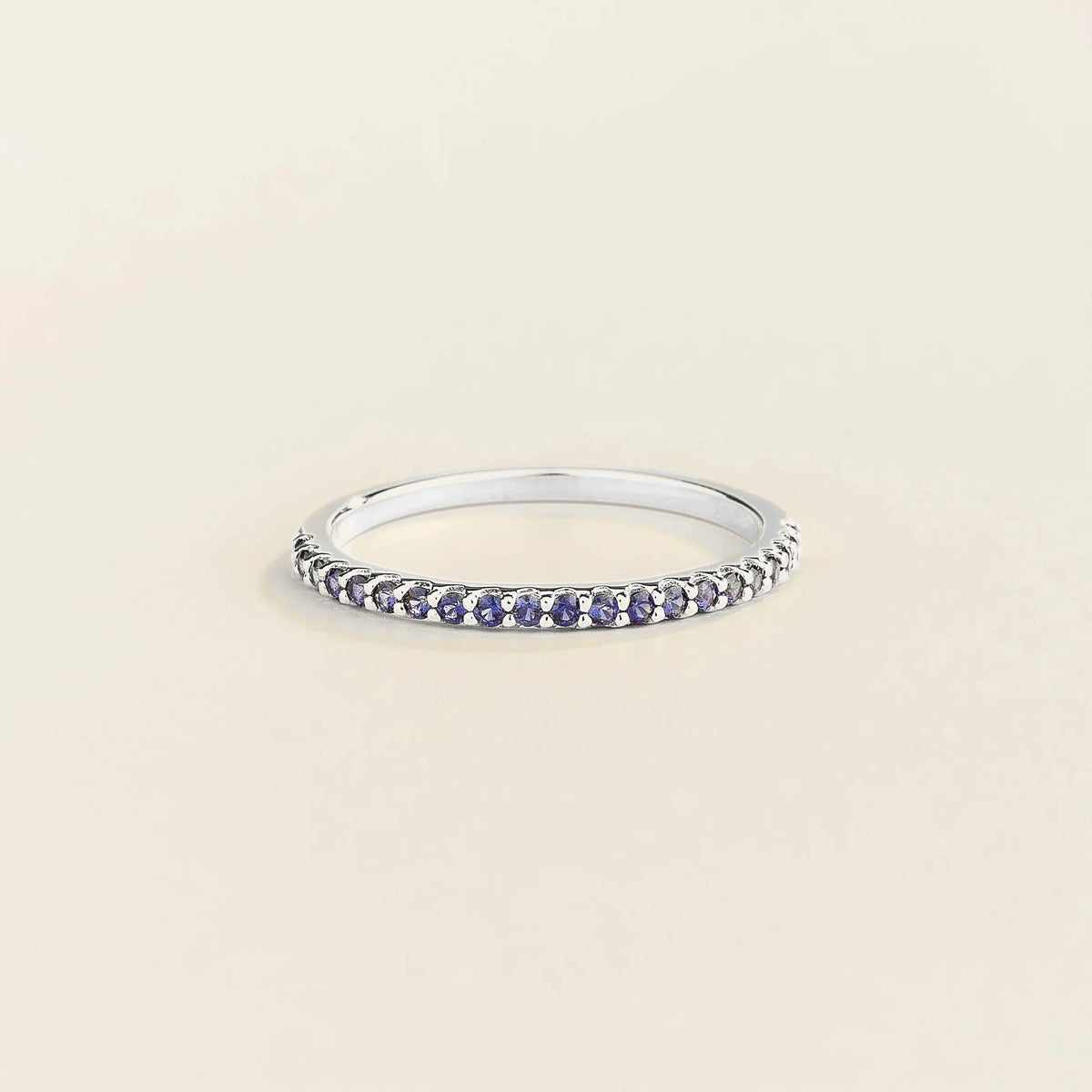 Juvetti white gold half eternity band set with round lab-grown blue sapphire gemstones.