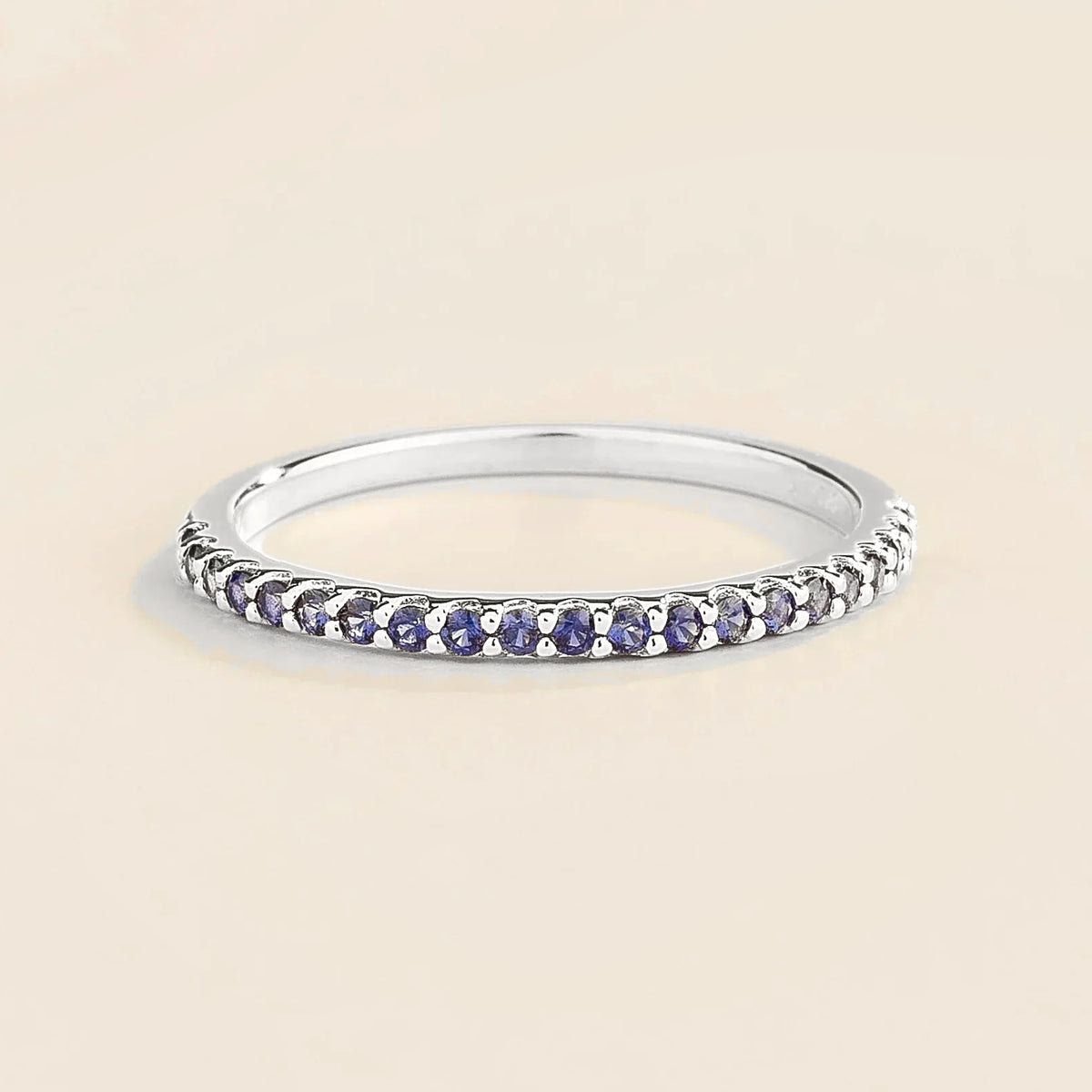 Juvetti white gold half eternity band set with round lab-grown blue sapphire gemstones.