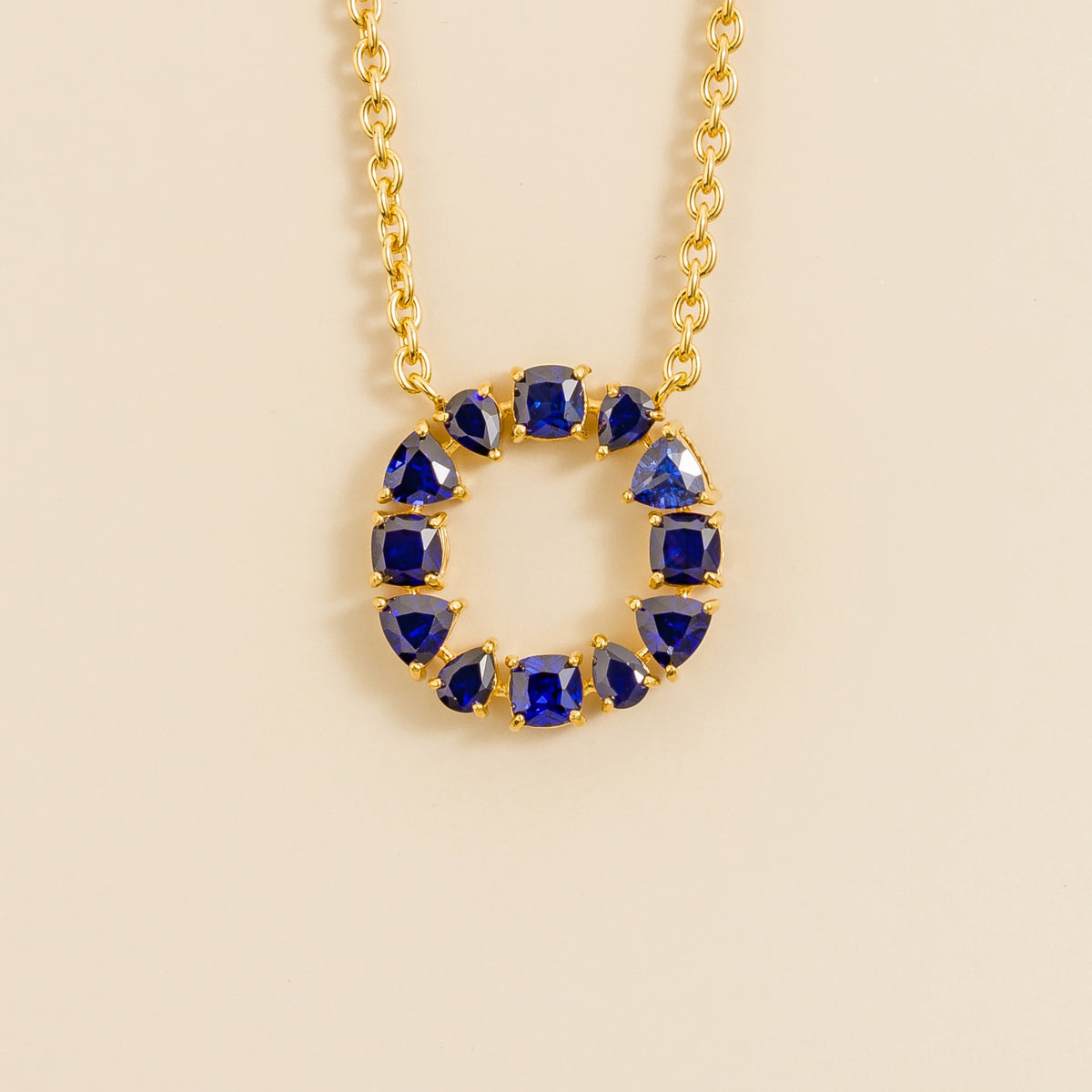 Glorie blue sapphire open circle pendant necklace in gold, mixed-cut lab-grown sapphires, front view | Juvetti London