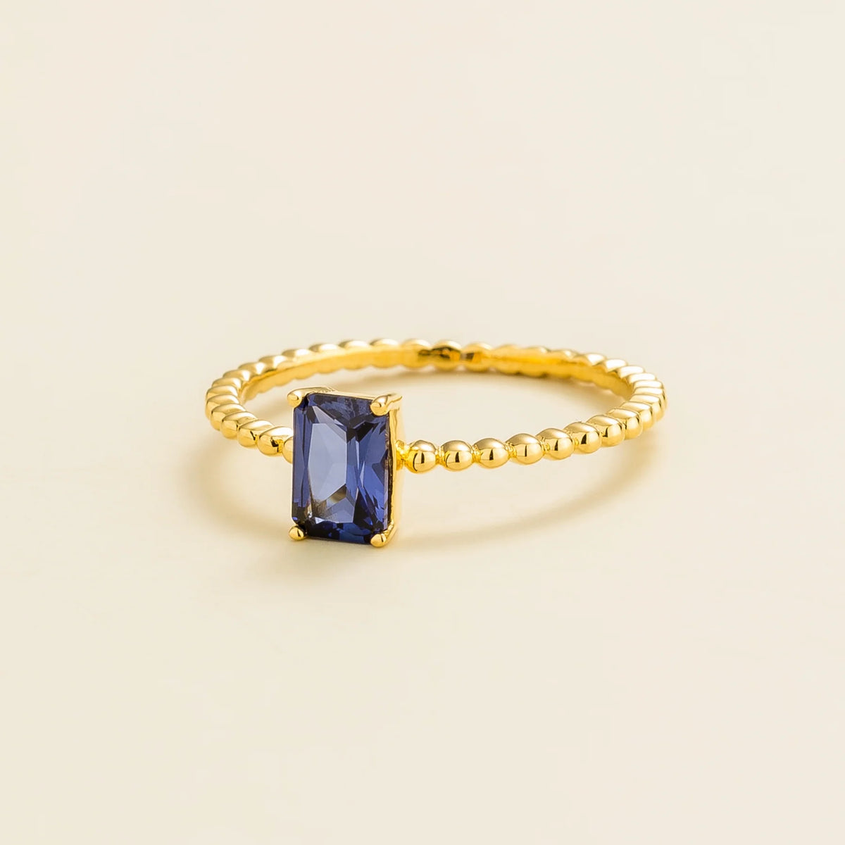 Fondi emerald-cut lab-grown blue sapphire beaded band ring in gold – angle view | Juvetti London