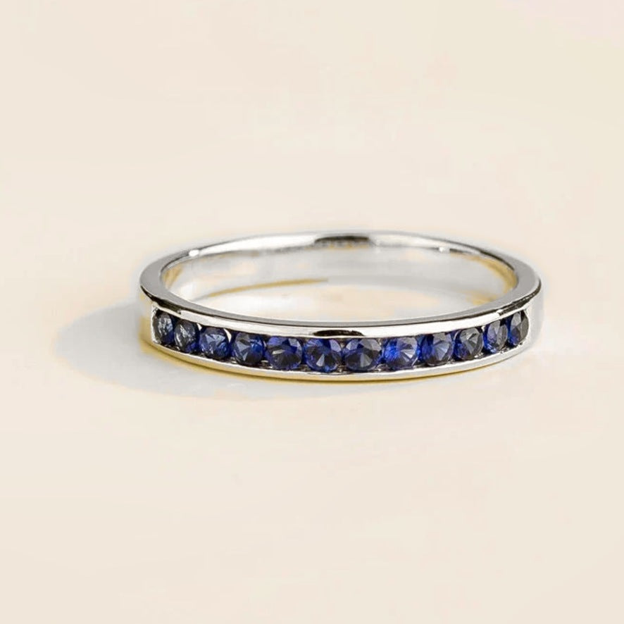 Margo blue sapphire channel set half eternity ring in white gold