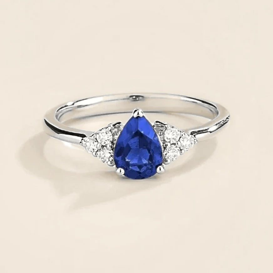 Pear-cut lab-grown blue sapphire and diamond ring in white gold – front view | Pisa by Juvetti