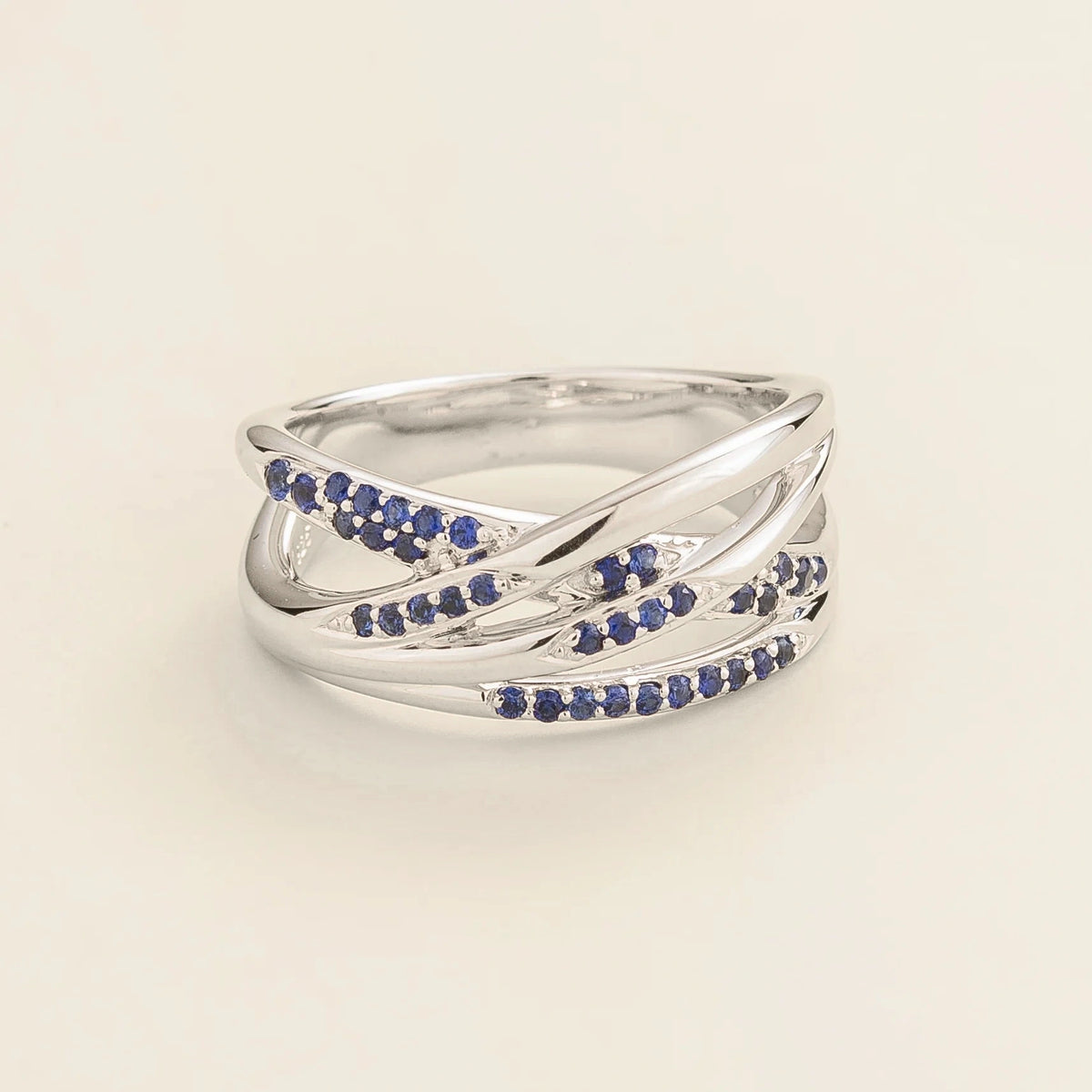 Val multi-row crossover band ring with lab-grown blue sapphires in white gold – front view | Juvetti London