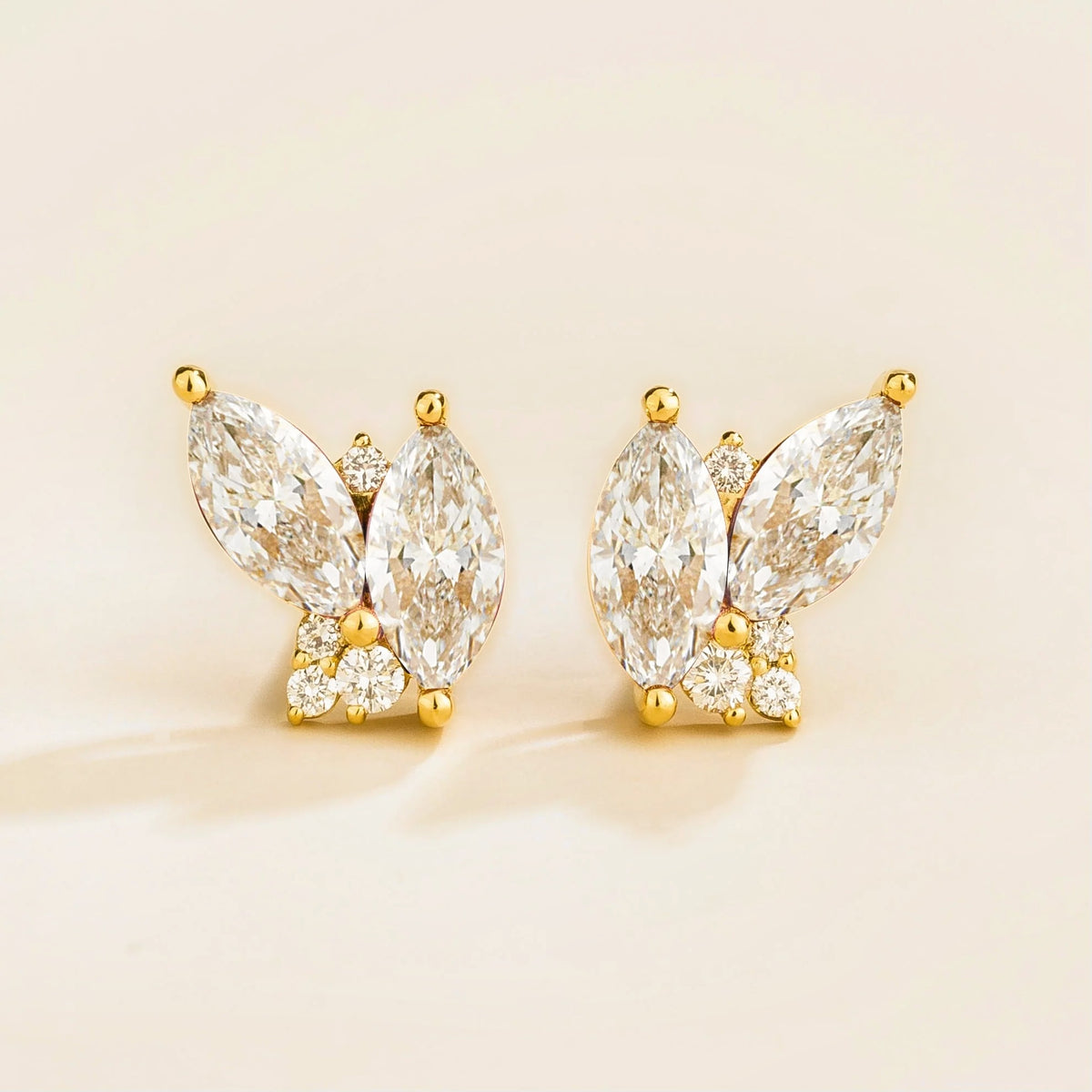 A pair of Vento gold earrings set with marquis diamonds and round diamonds.
