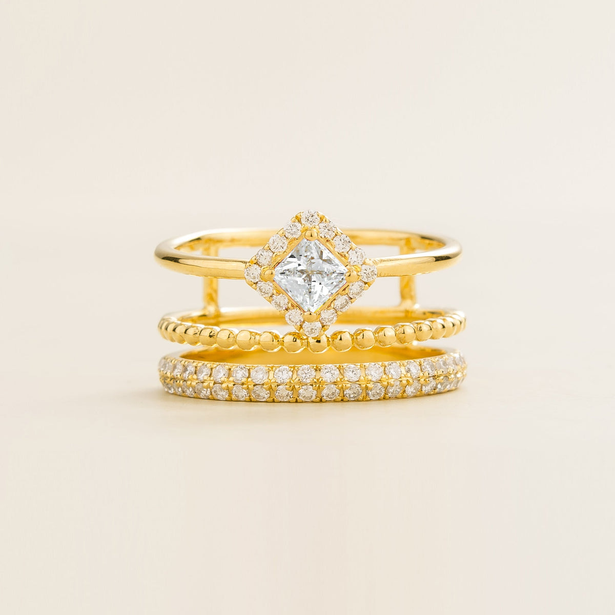Amici triple-band stacking ring in gold, princess-cut lab-grown diamond in a diamond halo with beaded and pavé bands, front view | Juvetti London