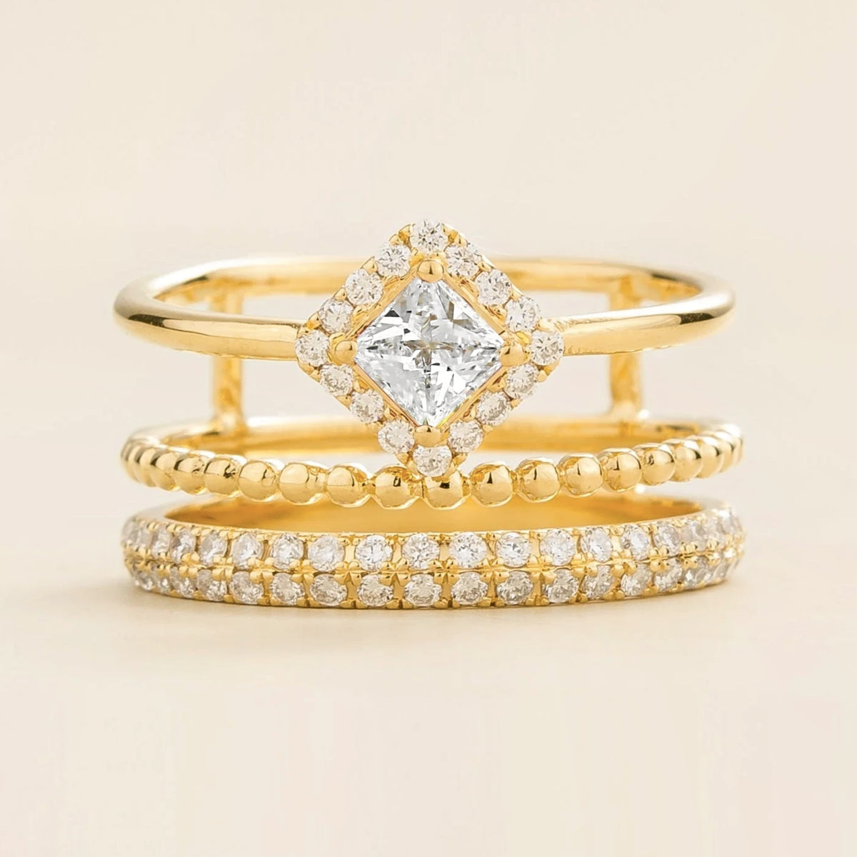 Amici triple-band stacking ring in gold, princess-cut lab-grown diamond in a diamond halo with beaded and pavé bands, front view | Juvetti London