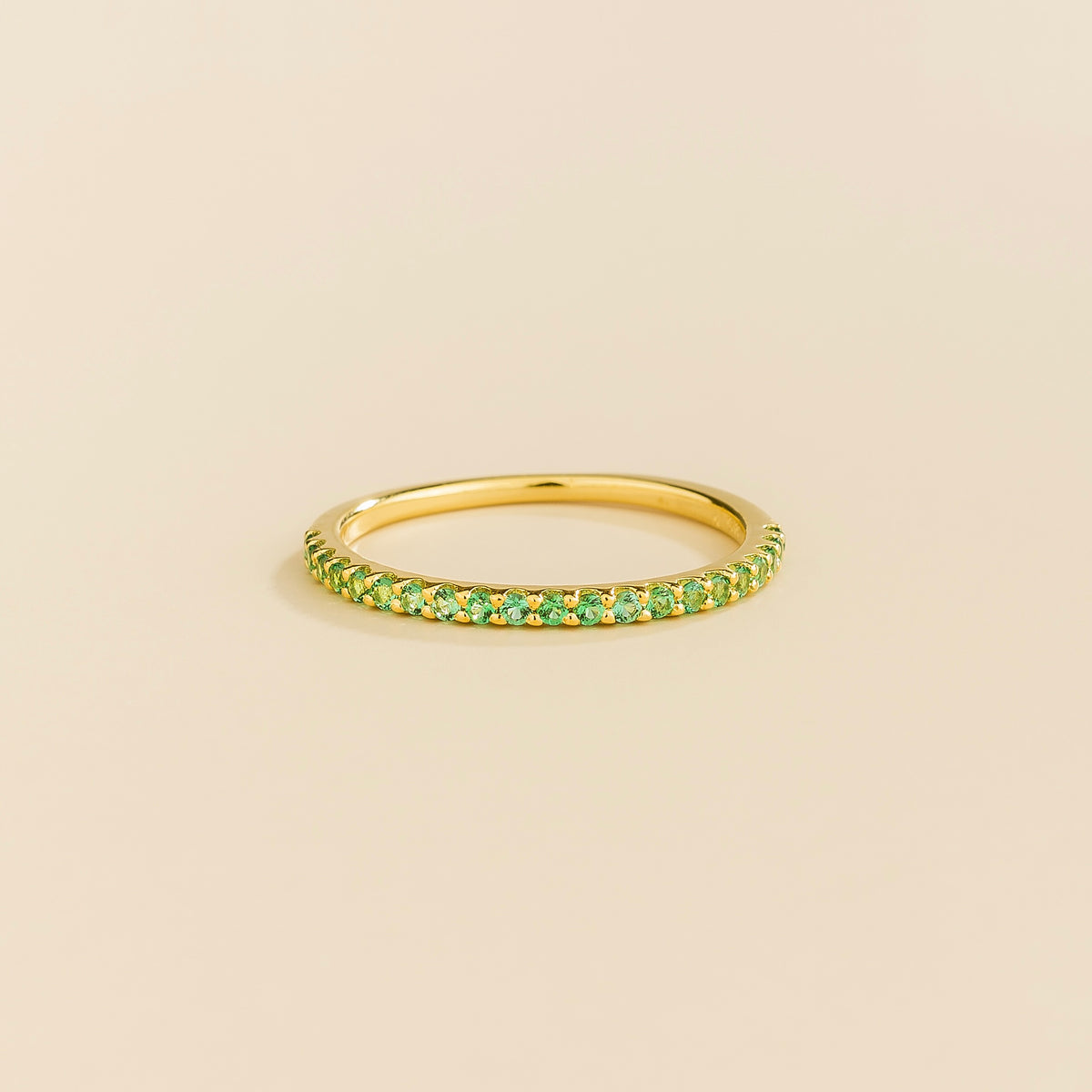Juvetti yellow gold half eternity band set with round lab-grown emeralds.