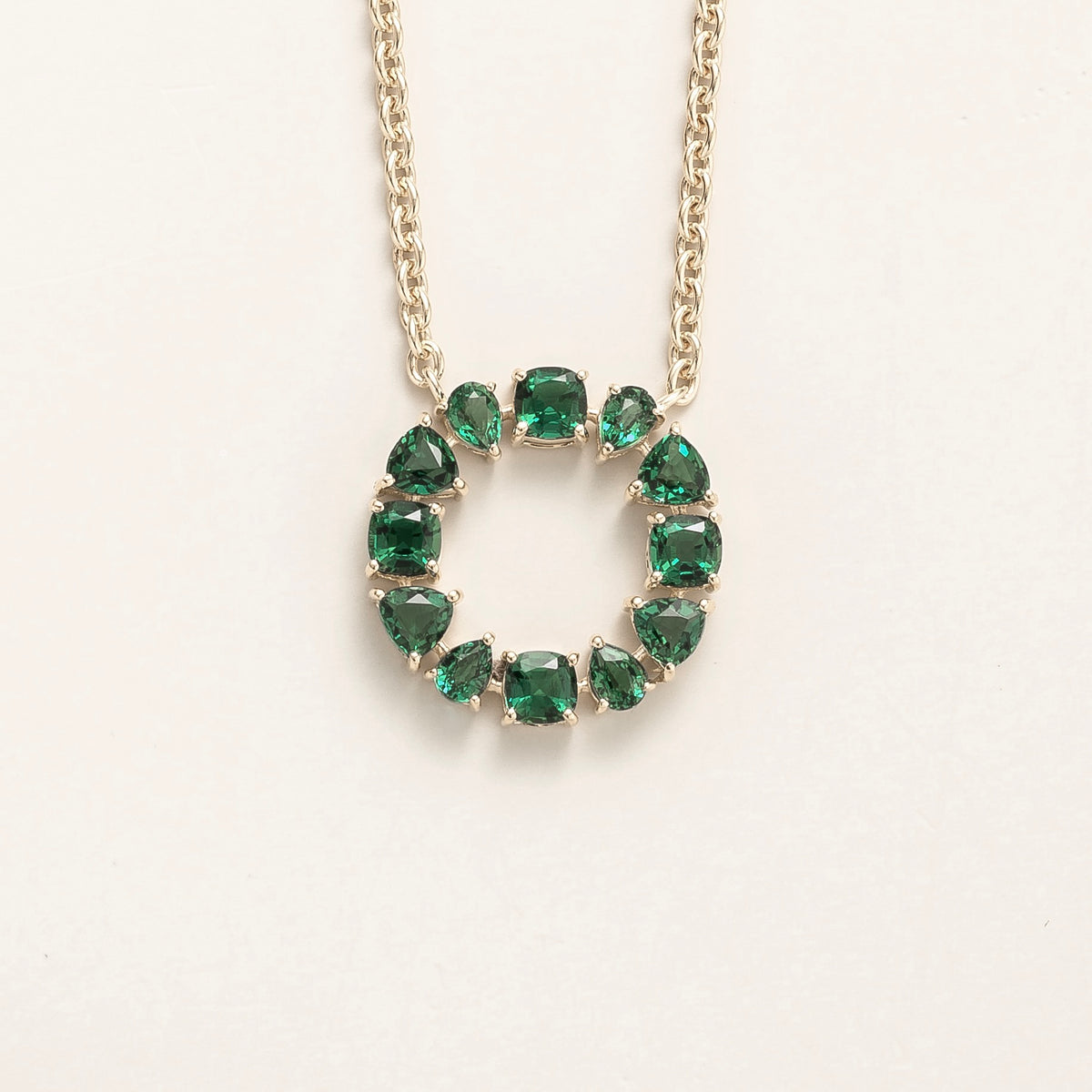 Glorie emerald open circle pendant necklace in white gold, mixed-cut lab-grown emeralds, front view | Juvetti London