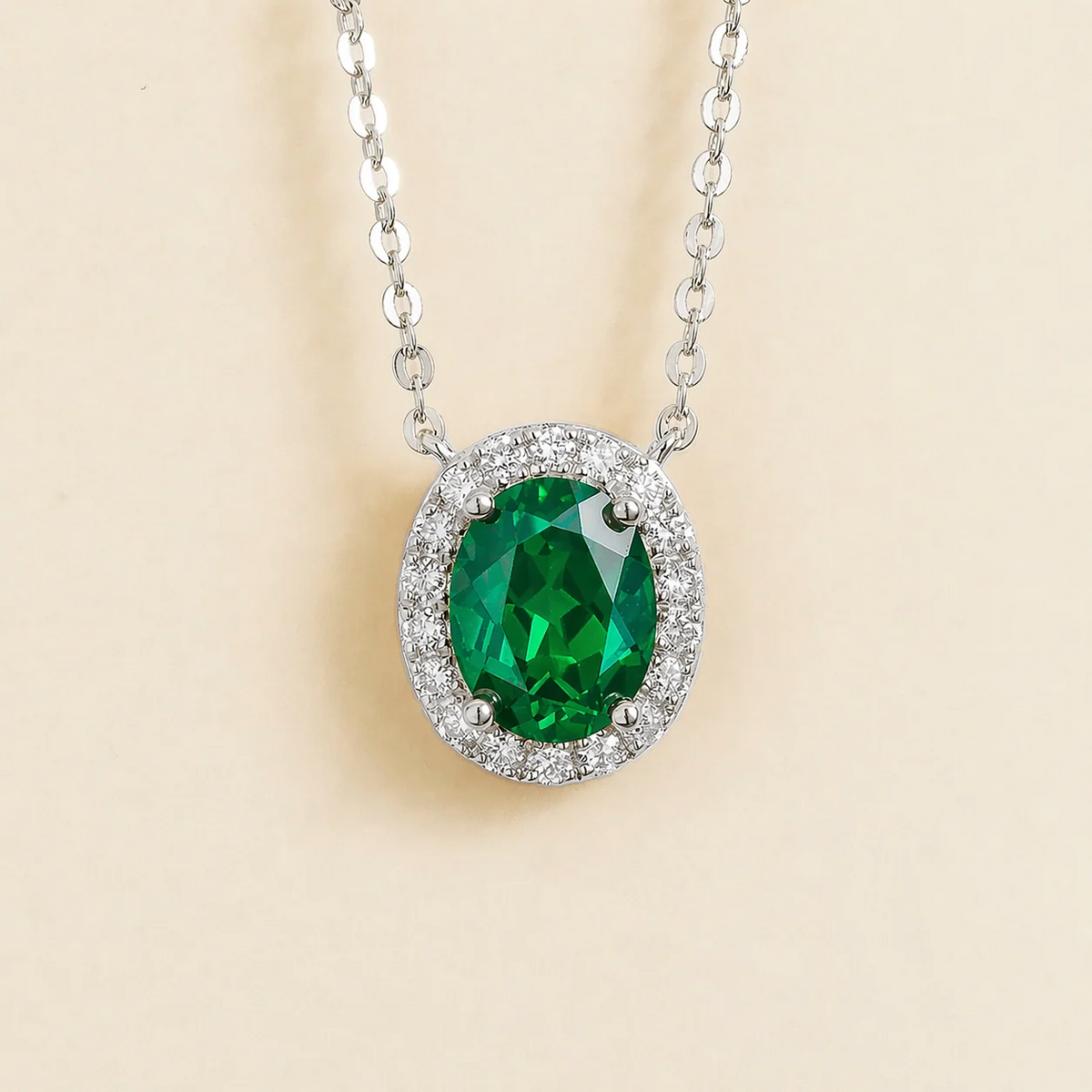 Lab-grown emerald and diamond oval halo necklace in white gold – front view | Mina by Juvetti