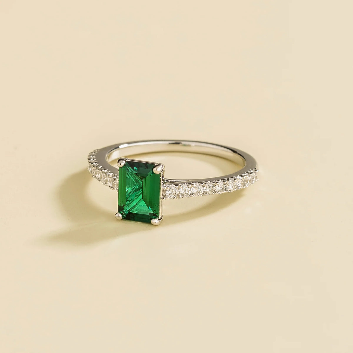 Chelle emerald-cut emerald and diamond pavé solitaire ring in white gold – angle view
