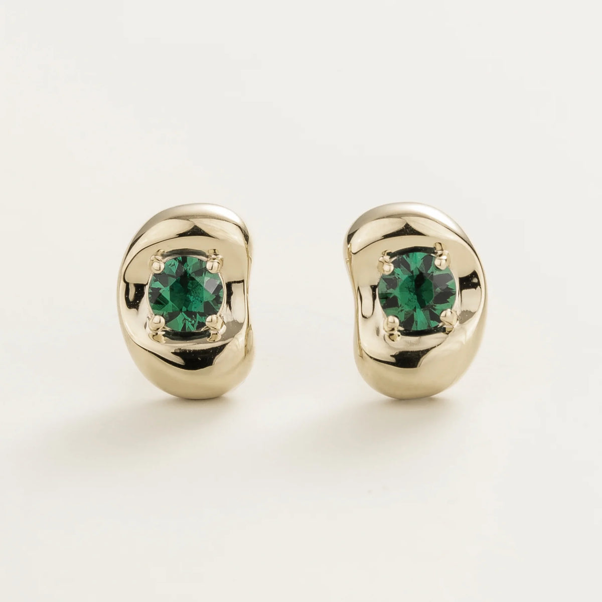 Fava round lab-grown emerald stud earrings in white gold, sculpted pebble setting, front view | Juvetti London