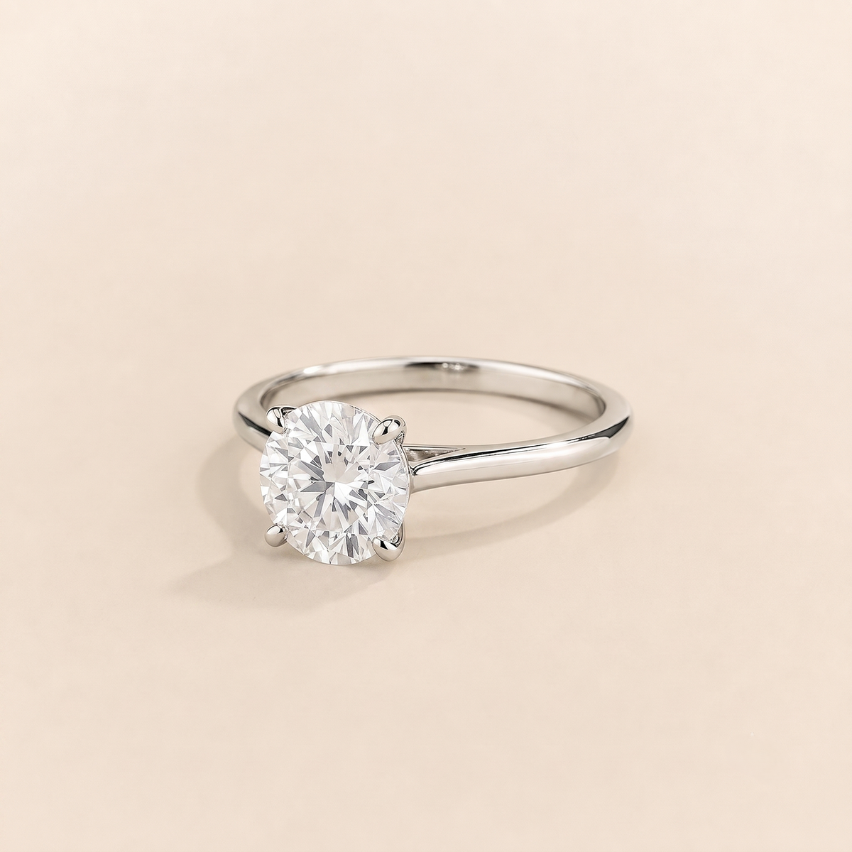 Kissen Ring in white gold, set with a round cut Diamond in an east–west setting.