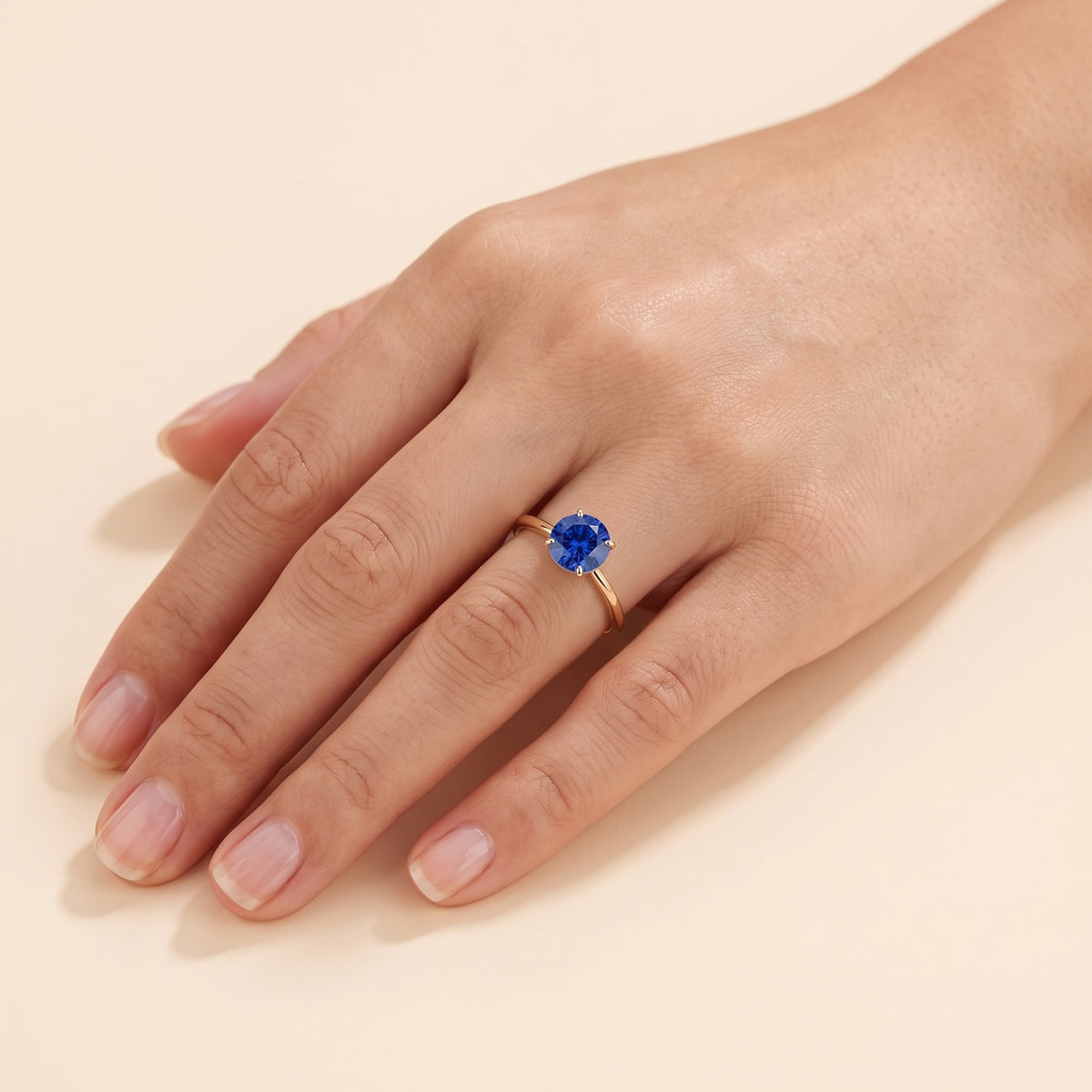 Model wearing the Nina Round Shape Blue Sapphire Cathedral Solitaire Ring in Gold