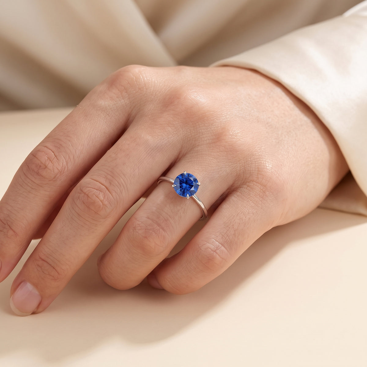 Model wearing the Nina Round Shape Blue Sapphire Cathedral Solitaire Ring in White Gold