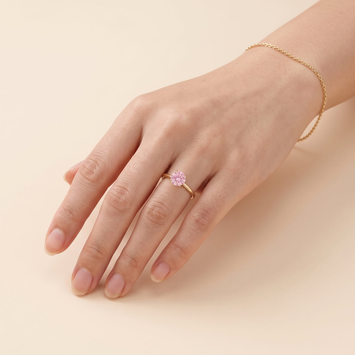 Model wearing the Nina Round Shape Pastel Pink Sapphire Cathedral Solitaire Ring in Gold