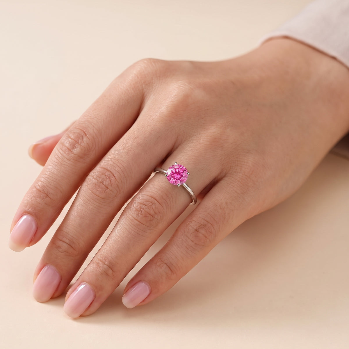 Model wearing the Nina Round Shape Vivid Pink Sapphire Cathedral Solitaire Ring in White Gold
