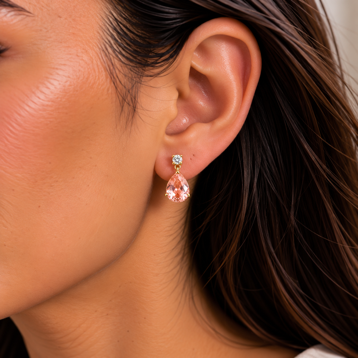 Medium lab-grown Padparadscha sapphire and diamond pear drop earrings in gold worn on model | Pisa by Juvetti